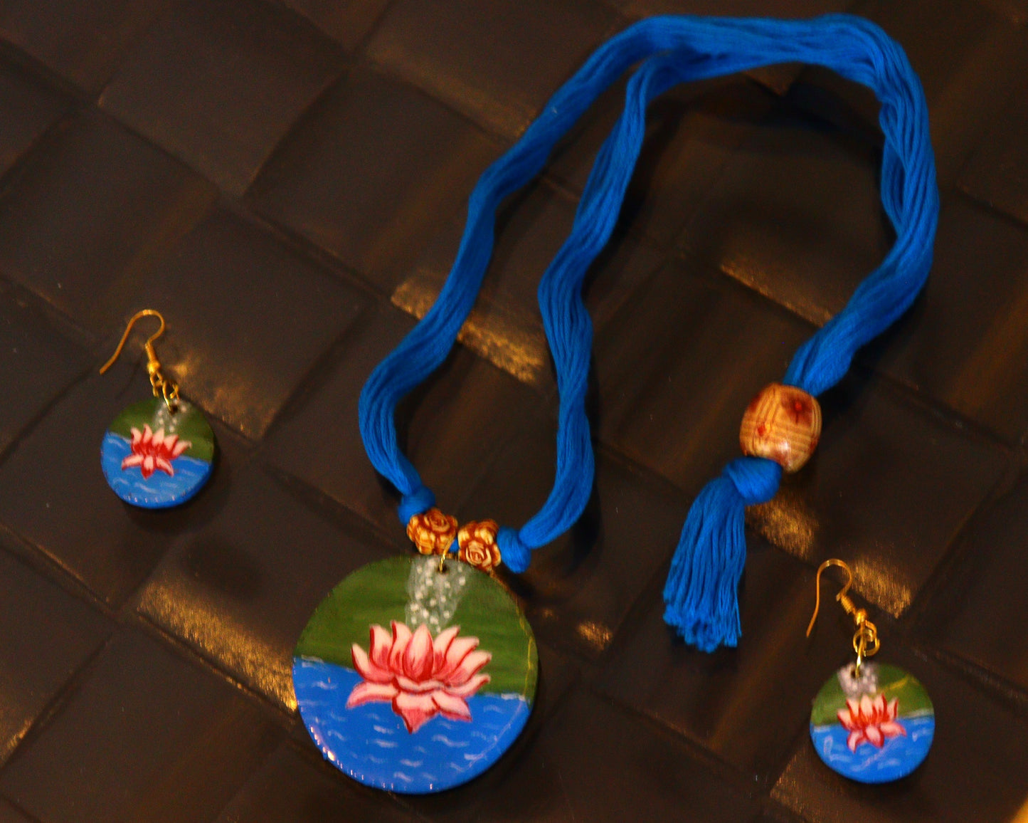 Jewelry set with necklace and earrings on a textured surface