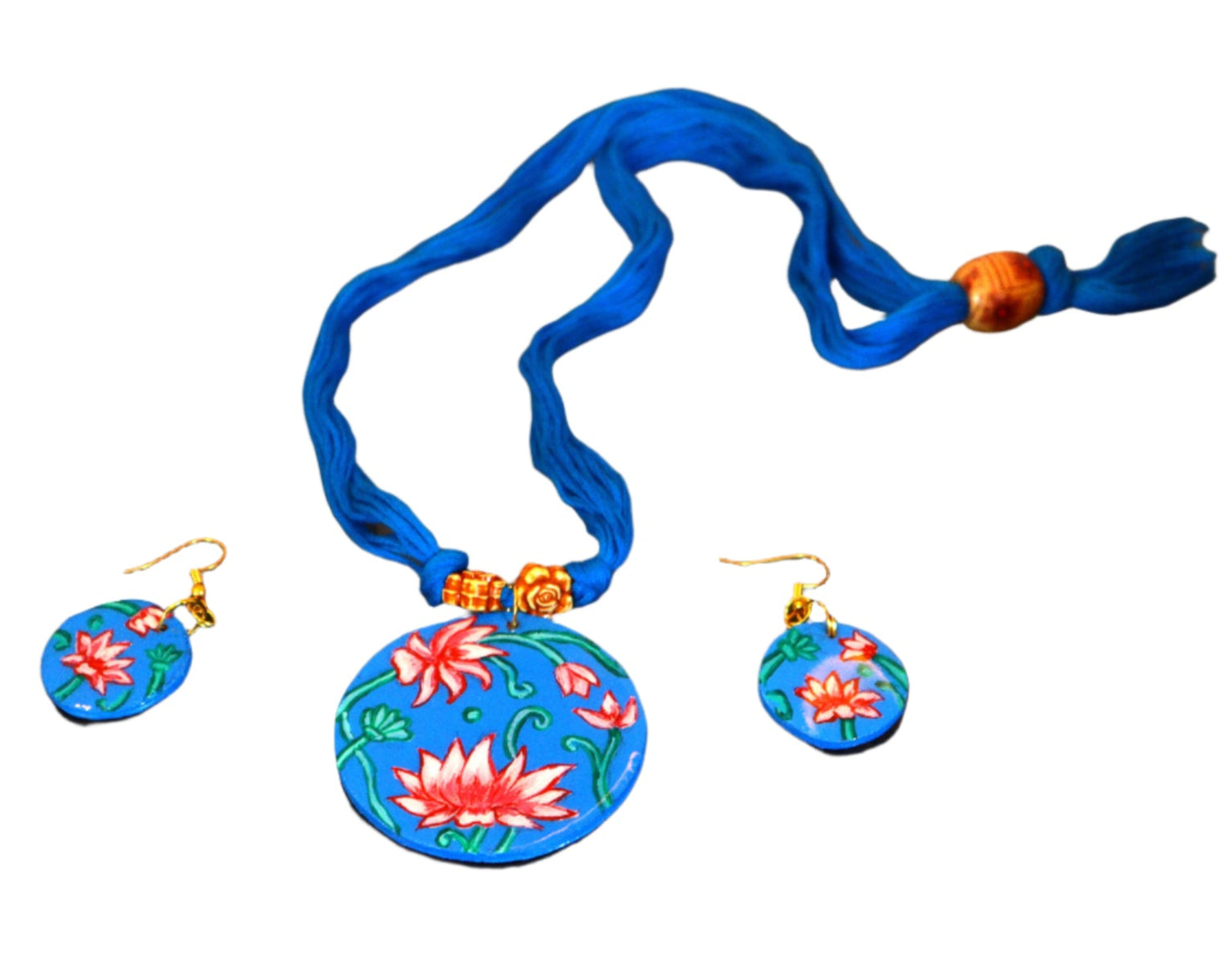 Jewelry set with floral pendant and earrings on a dark textured surface