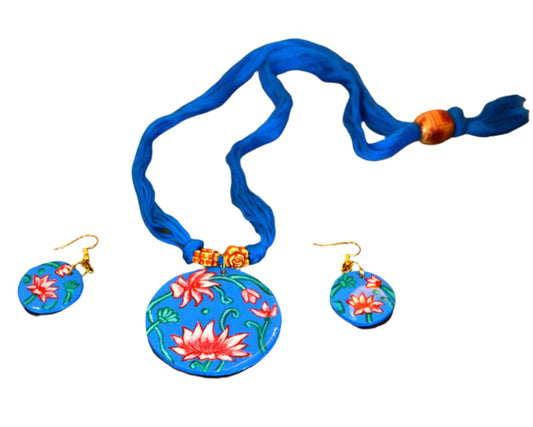 Jewelry set with floral pendant and earrings on a dark textured surface