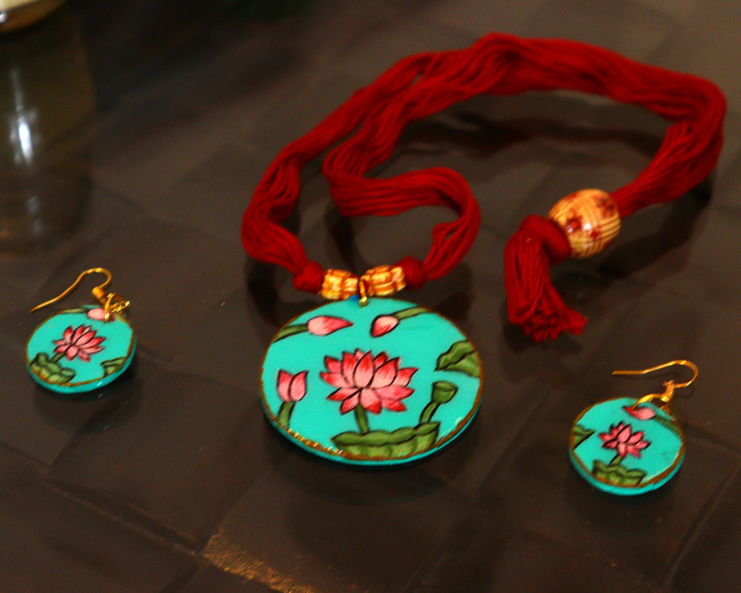 Turquoise jewelry set with floral designs on a dark surface