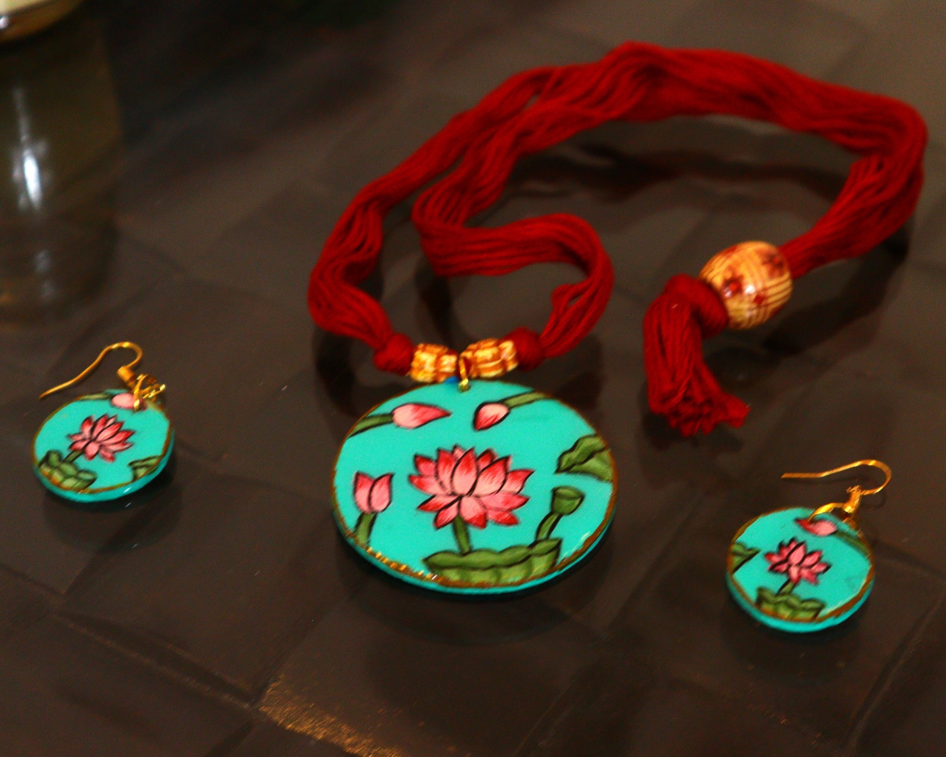 Turquoise jewelry set with floral designs on a dark surface