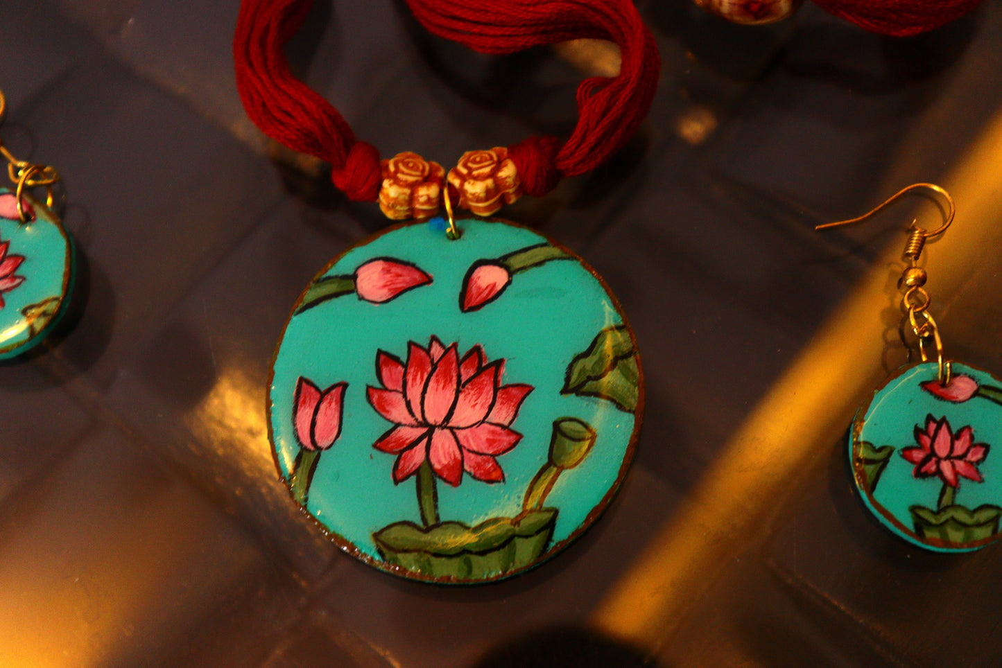 Decorative earrings with lotus design on a reflective surface