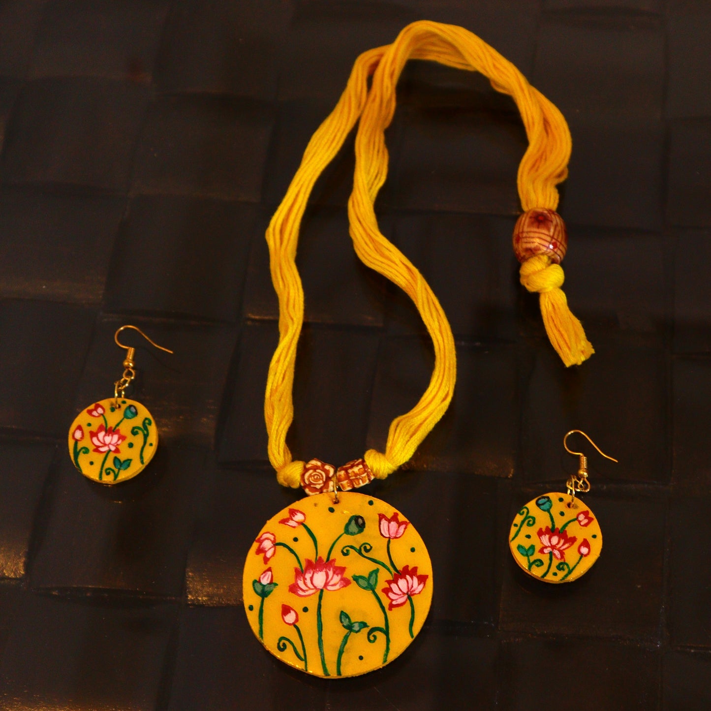 Yellow floral necklace and earrings set on a dark textured background