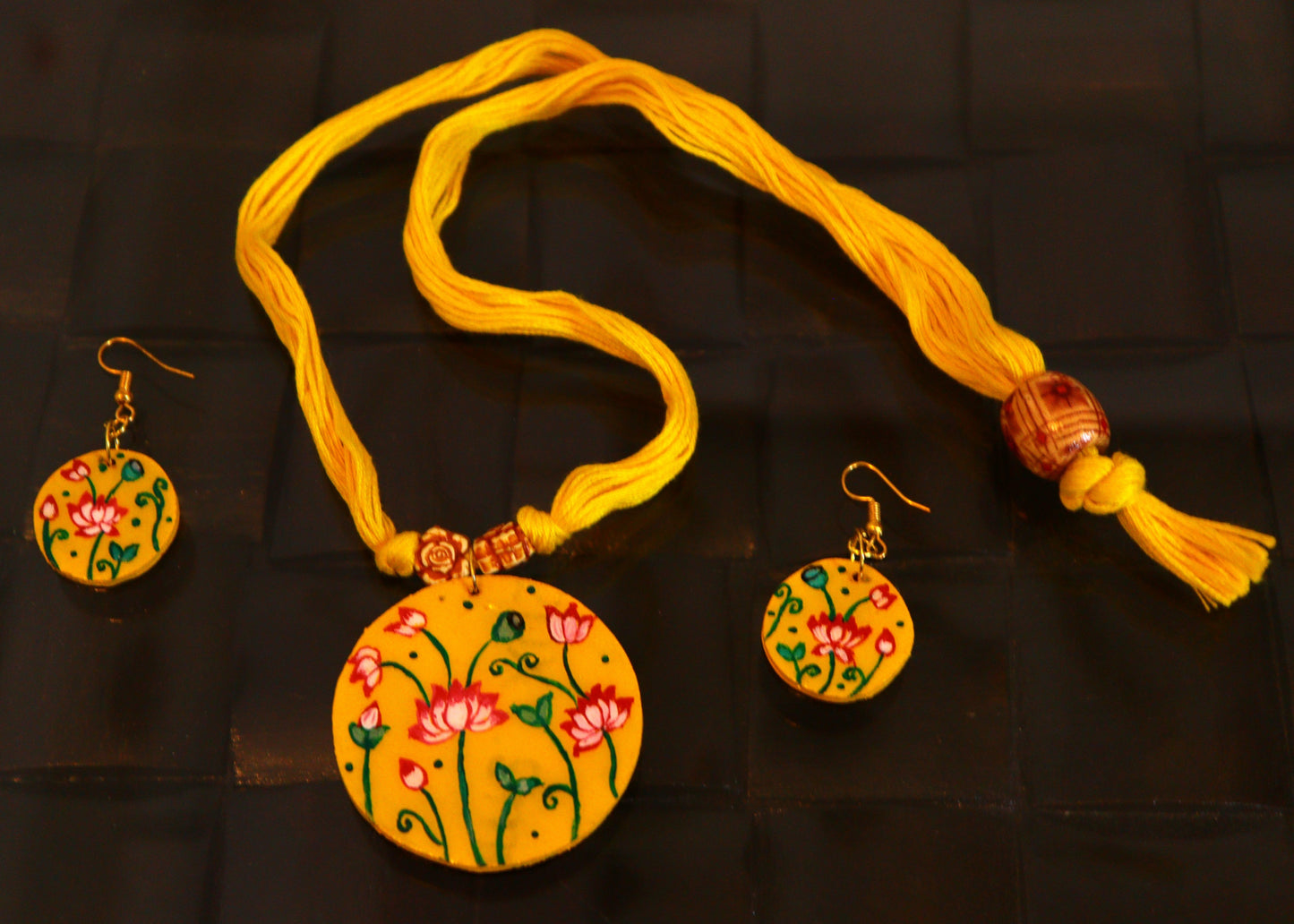 Jewelry set with yellow necklace and earrings on a dark background