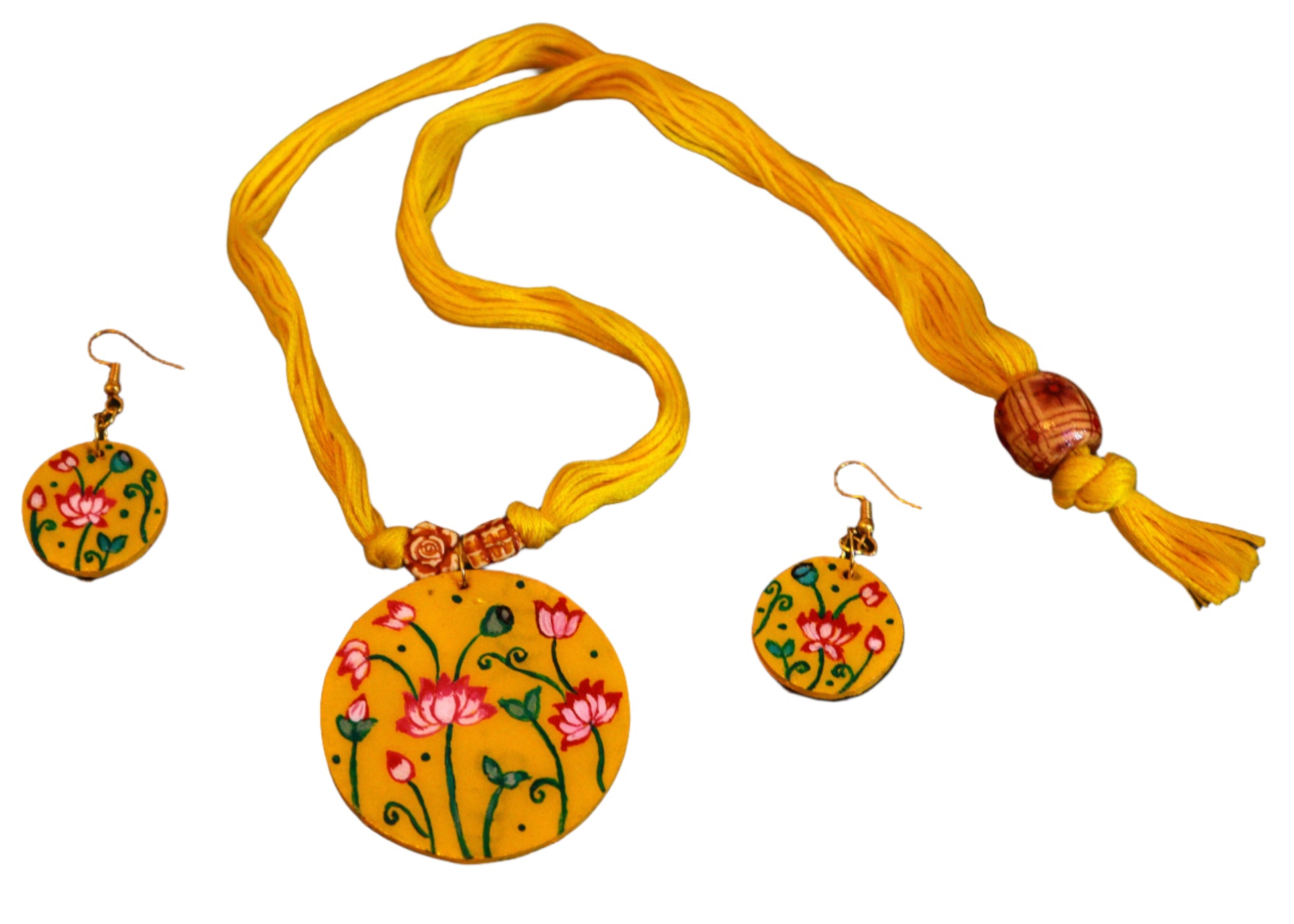 Jewelry set with yellow pendant and earrings on a dark fabric background
