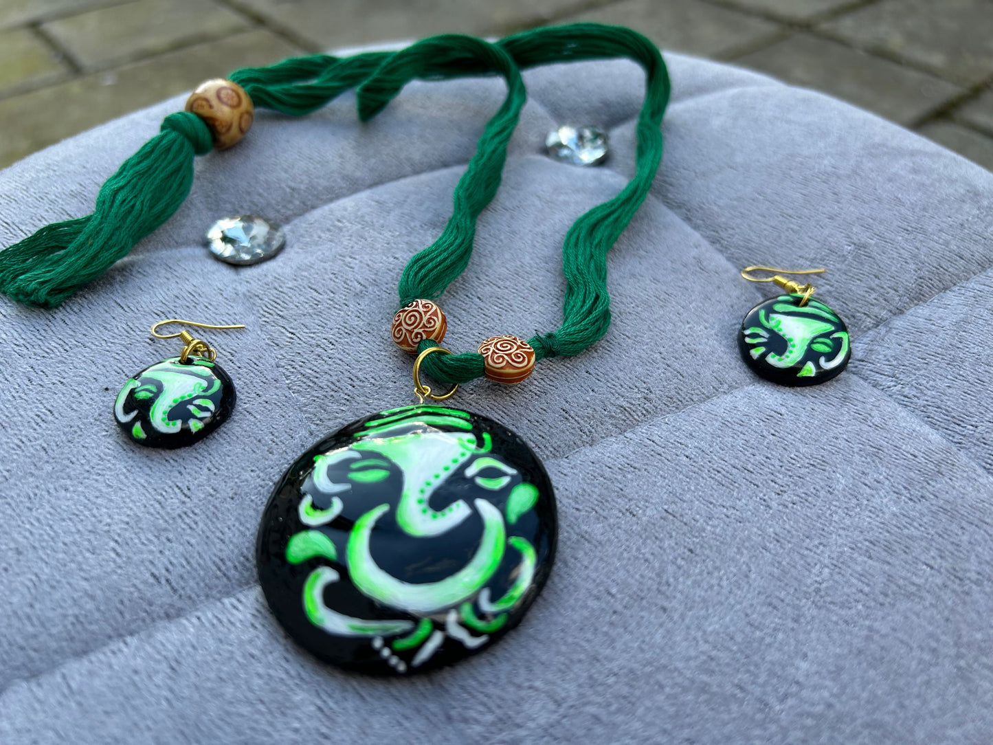 Jewelry set with pendant, necklace, and earrings on a textured surface