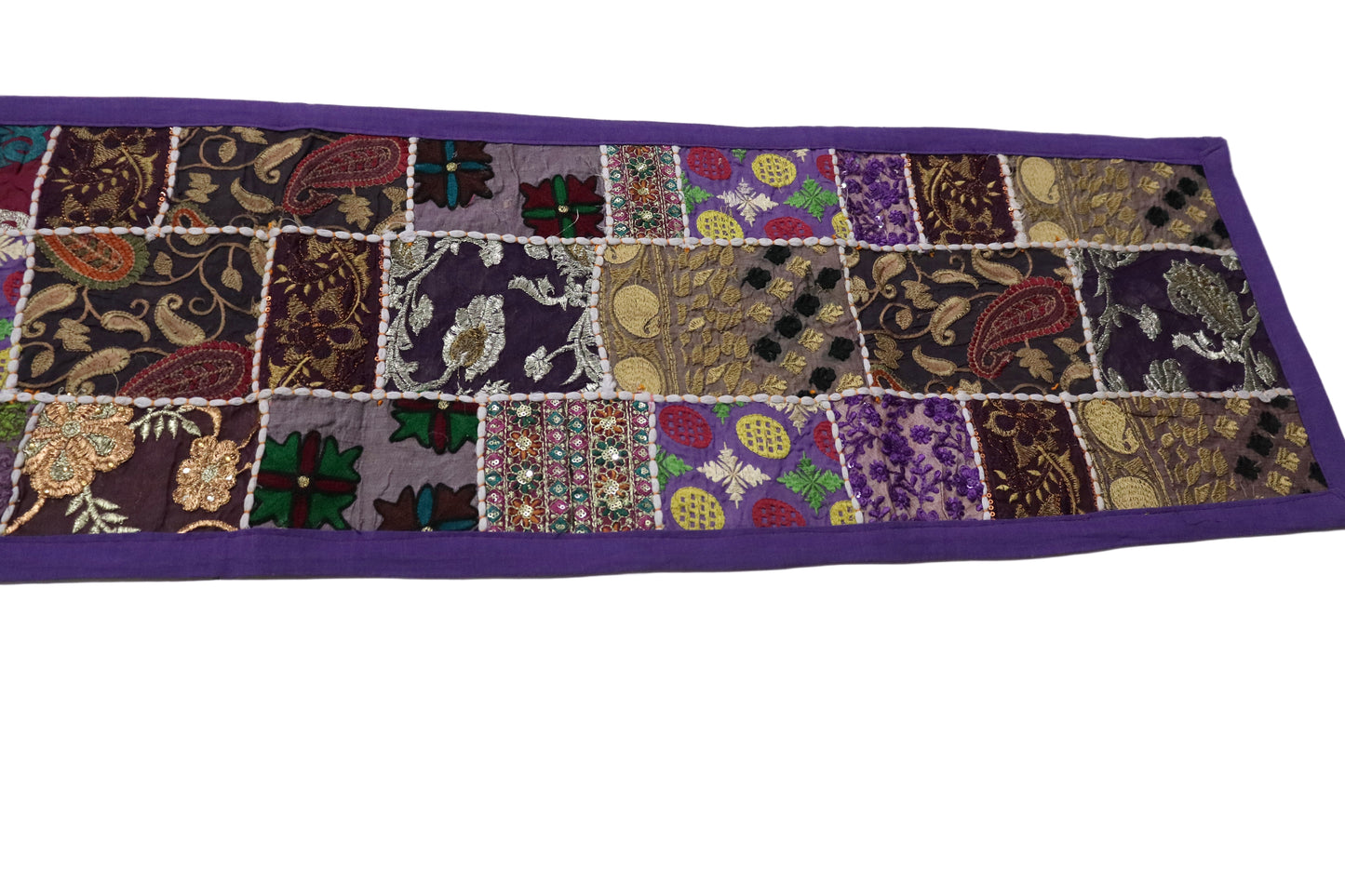 Patchwork table runner with various patterns on a white background
