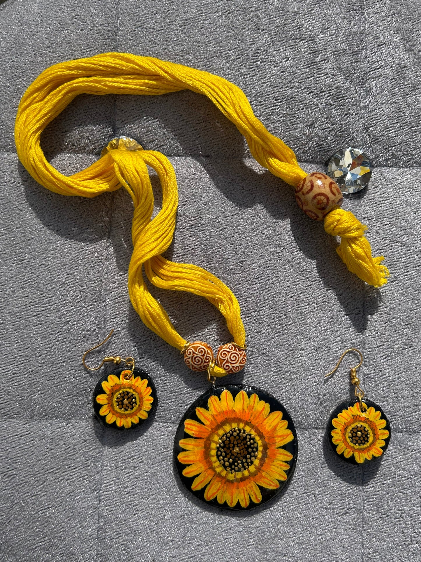 Yellow tassel with decorative elements on a gray surface