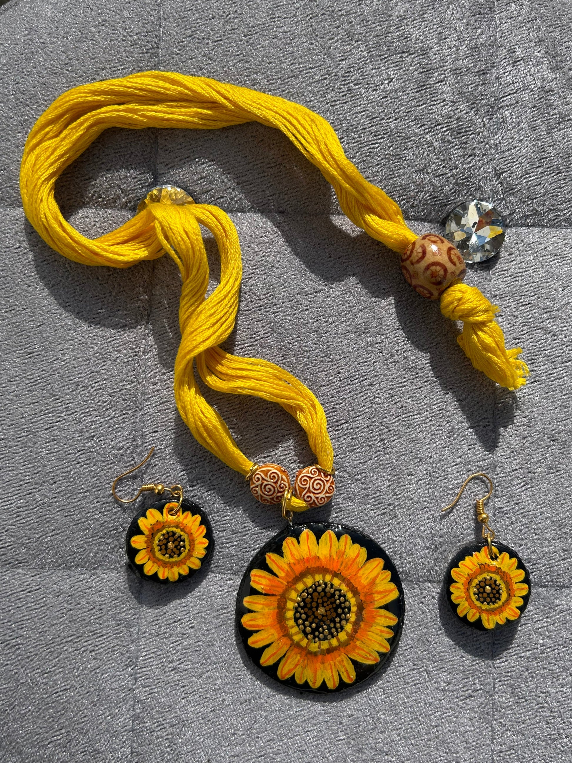 Yellow tassel with decorative elements on a gray surface