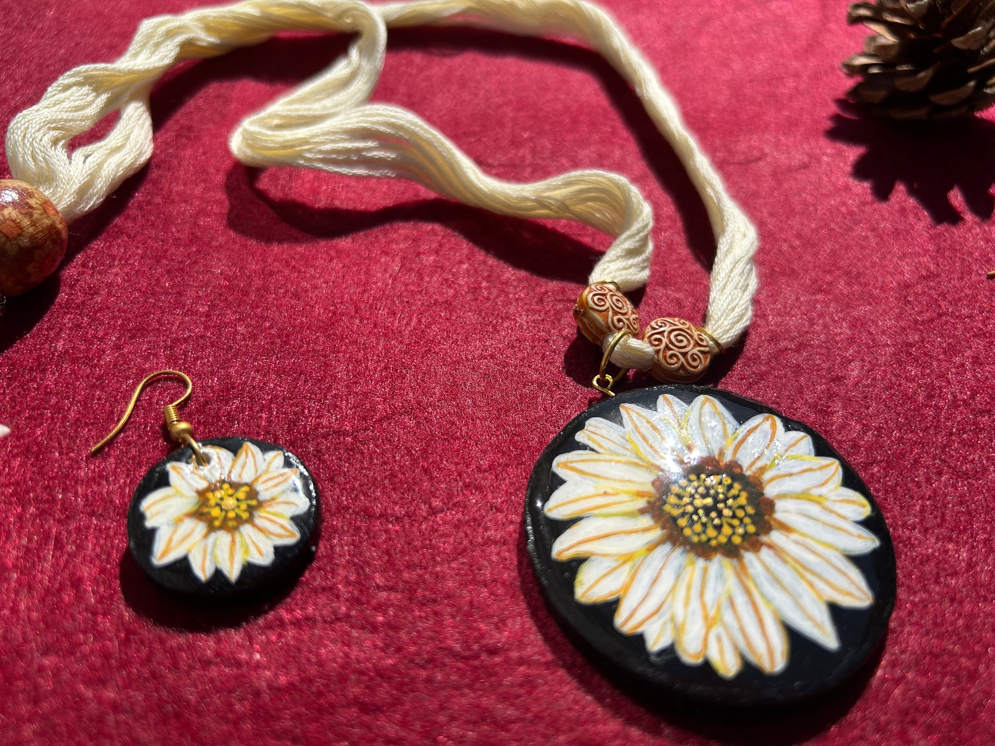 Jewelry set with a necklace and earrings featuring white flowers on a red background