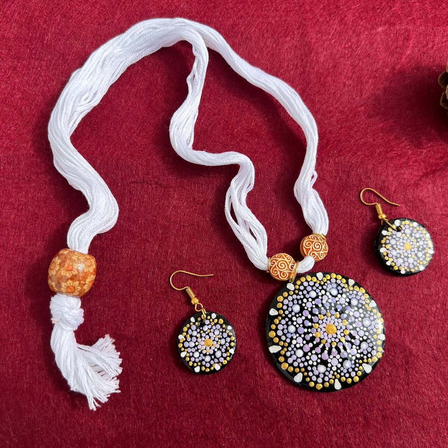 Jewelry set with necklace and earrings on a red fabric background