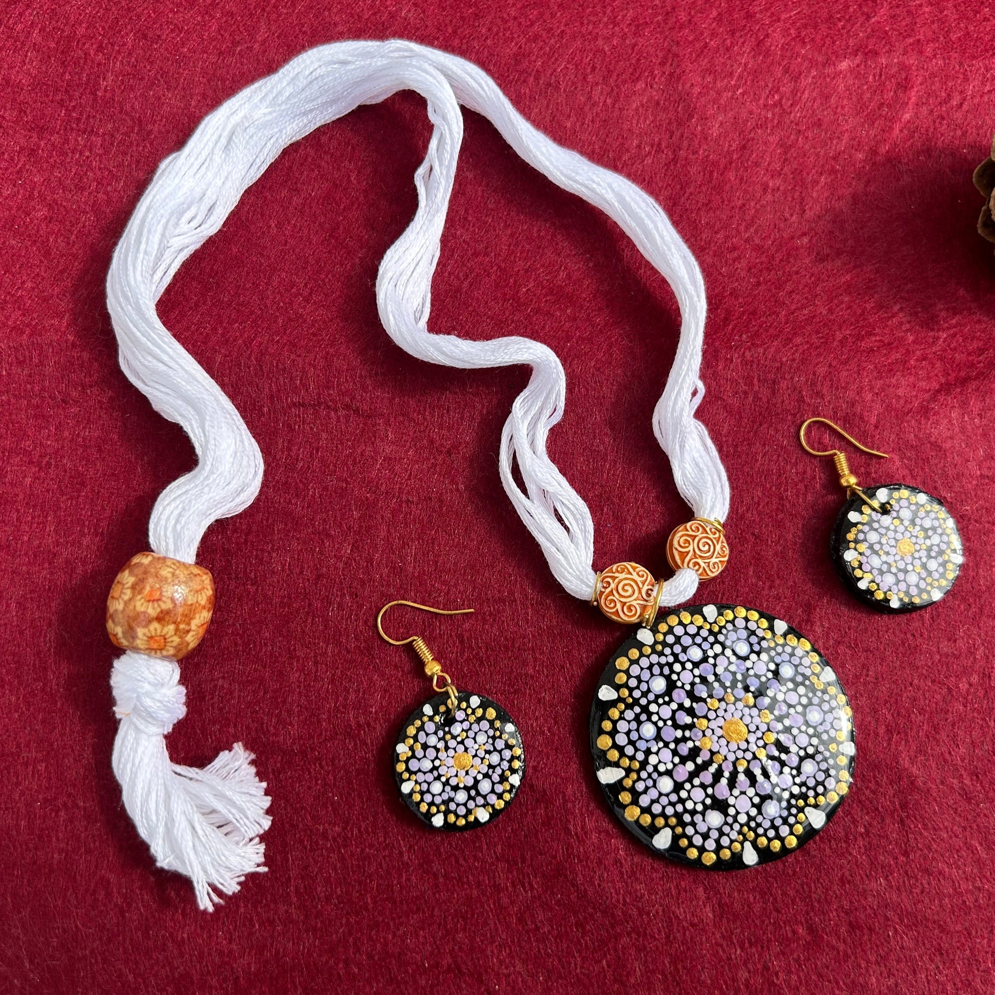 Jewelry set with necklace and earrings on a red fabric background