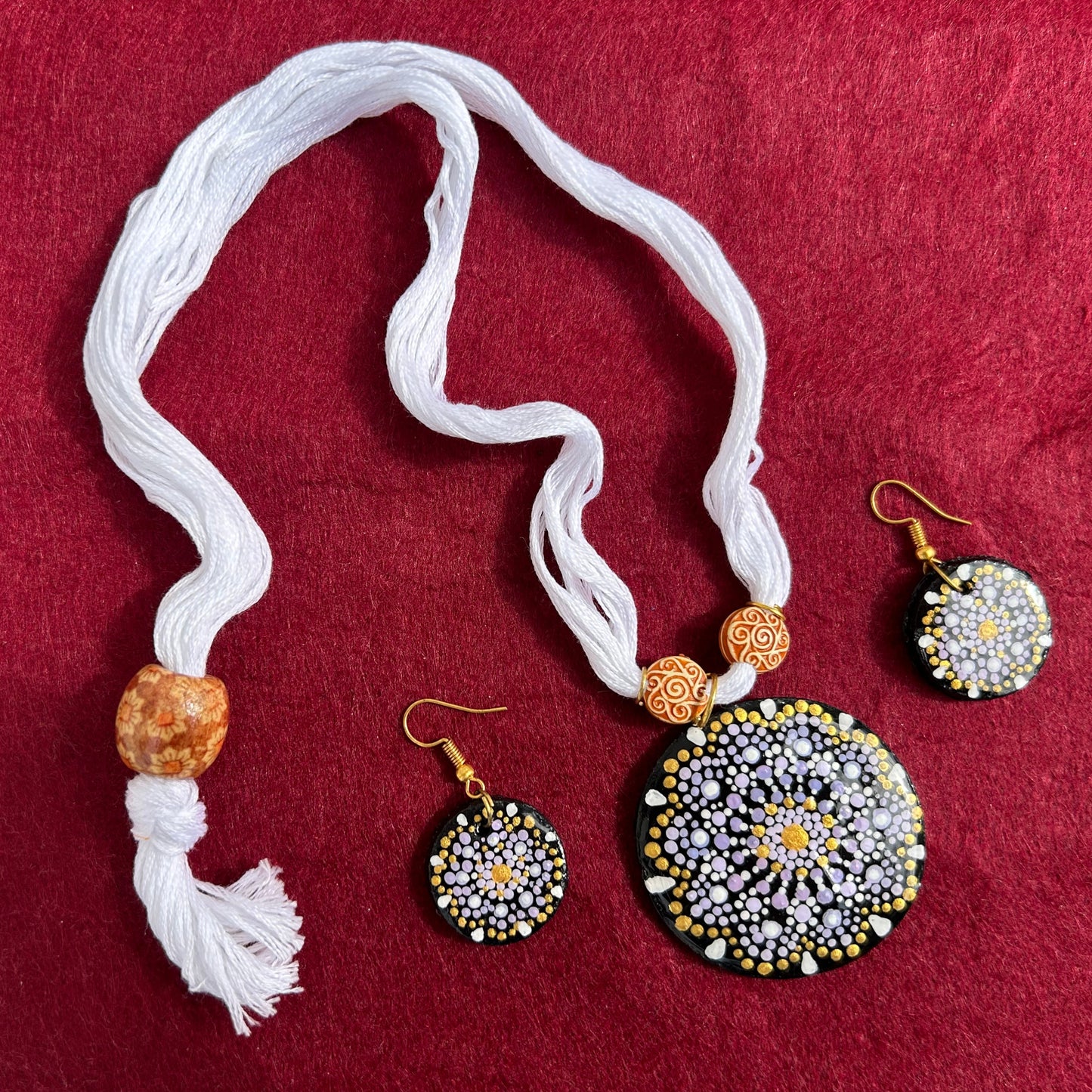 Jewelry set with necklace and earrings on a red fabric background