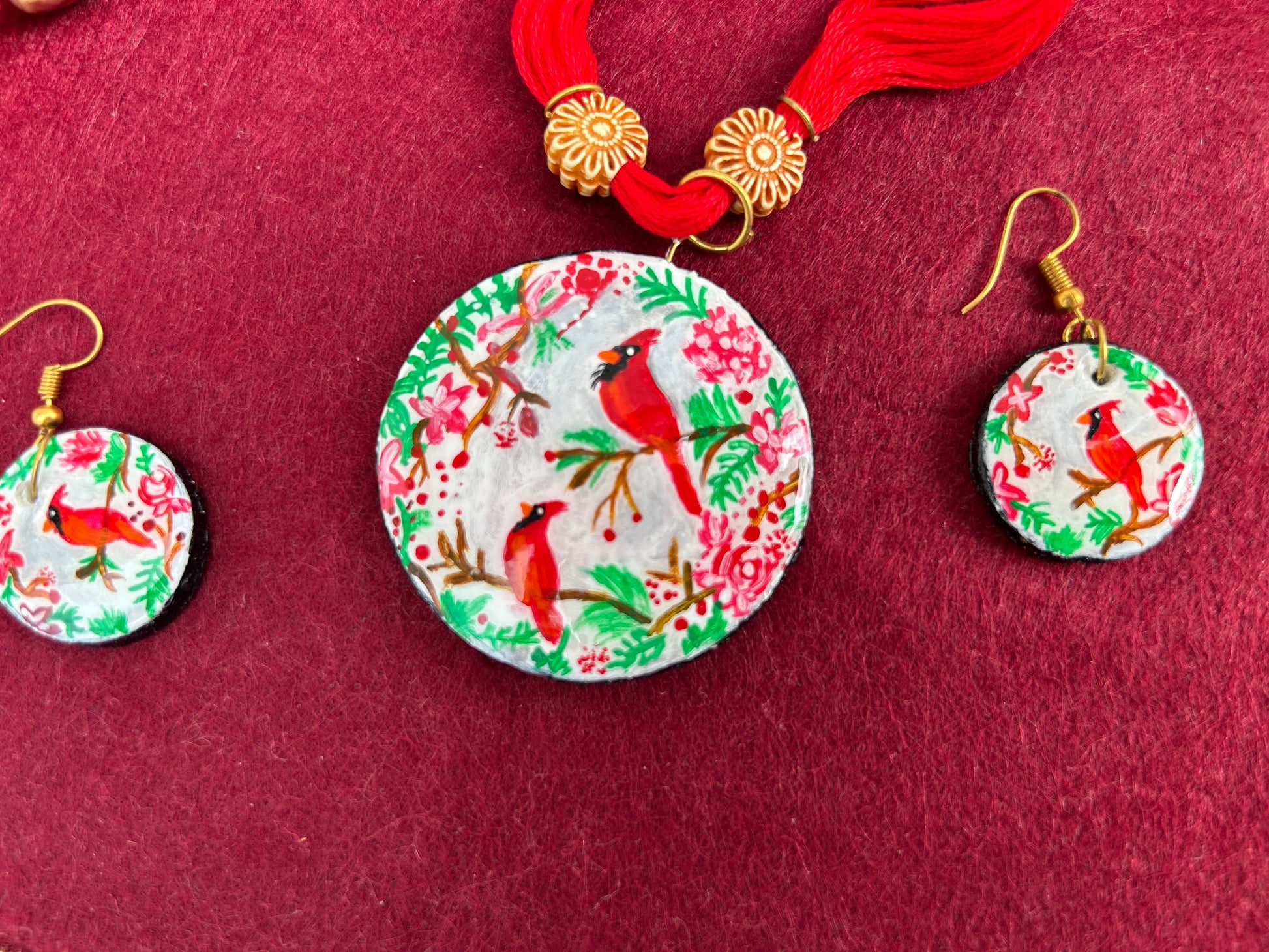 Round earrings with cardinal design on a red background