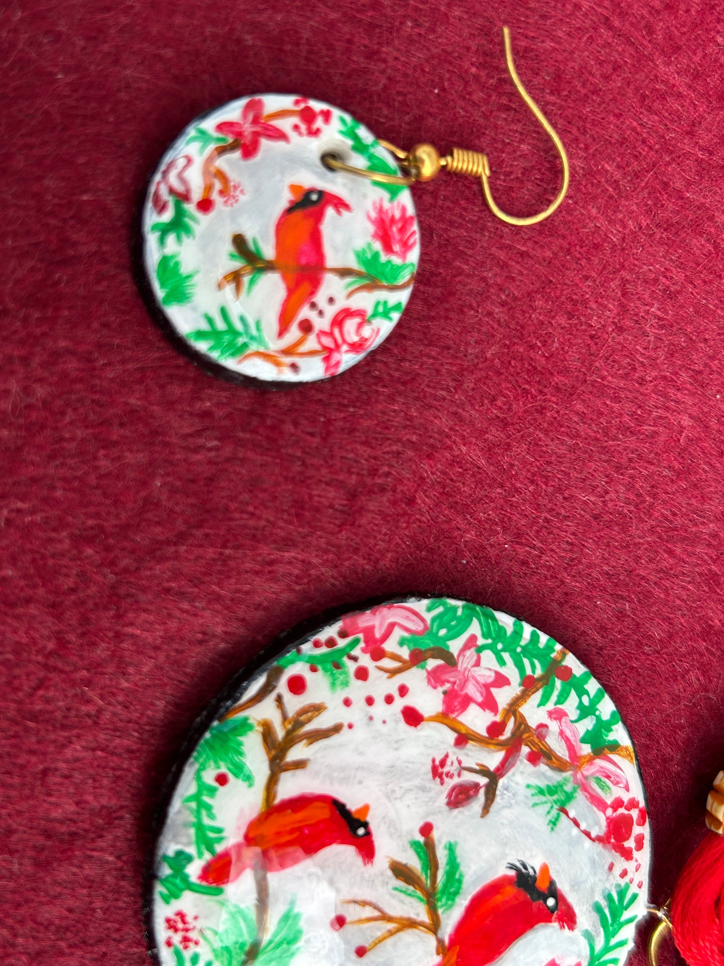 Round earrings with festive design on a red background