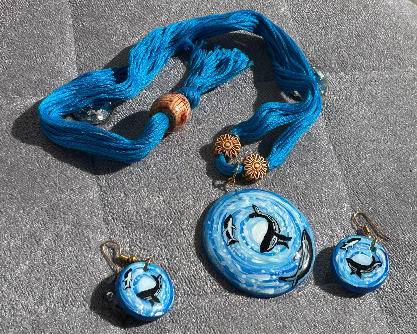 Blue jewelry set with necklaces and pendants on a textured surface