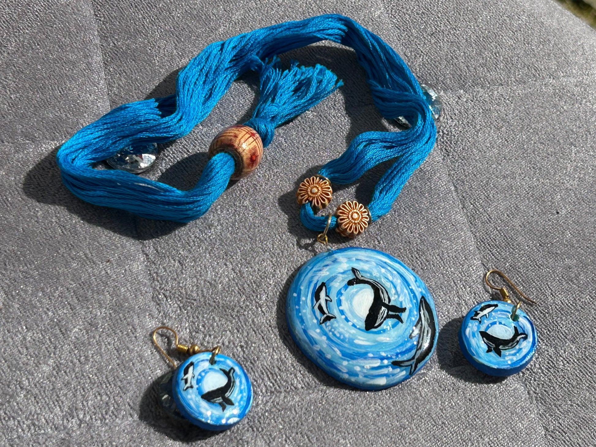 Blue jewelry set with necklaces and pendants on a textured surface
