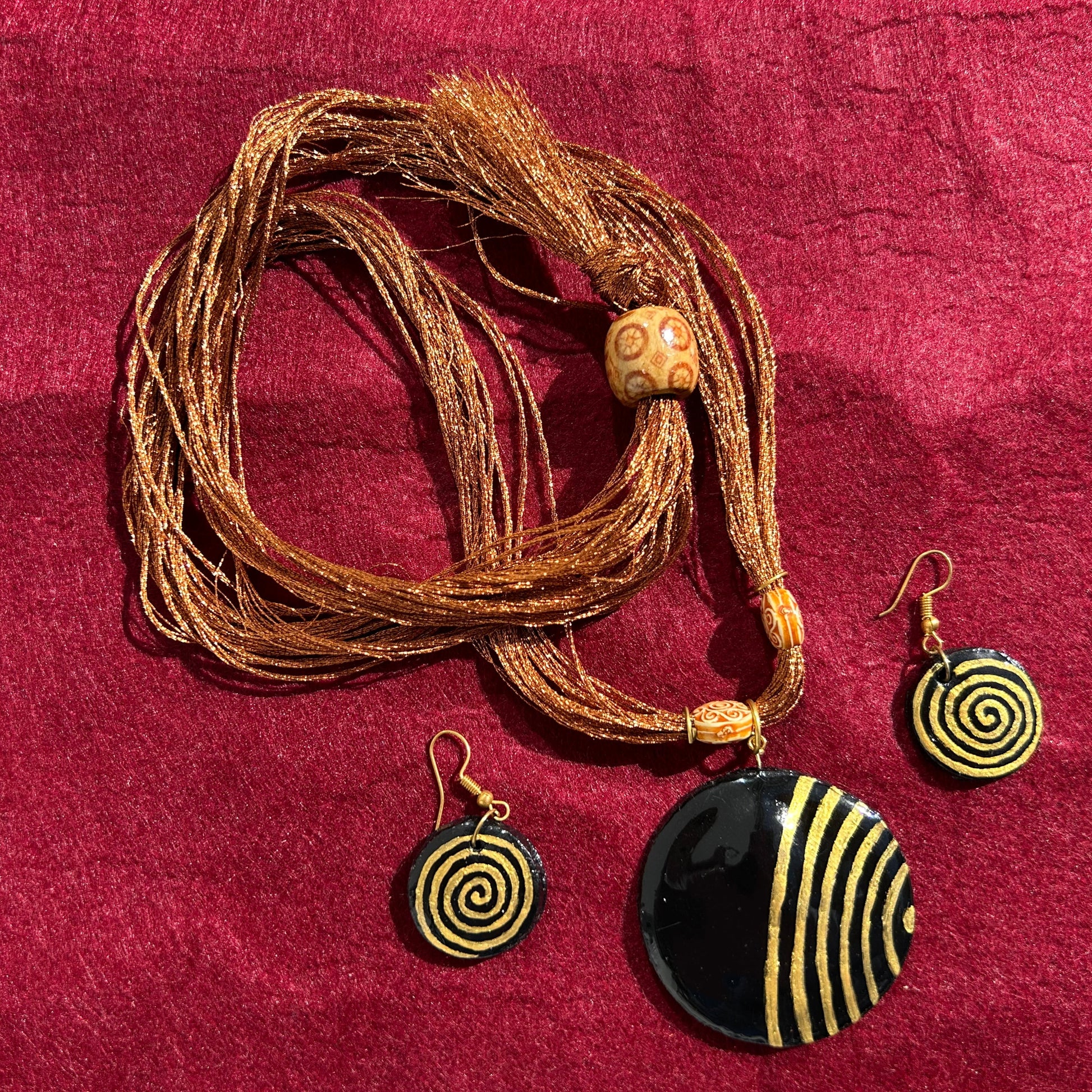 Jewelry set with necklace and earrings on a red fabric background