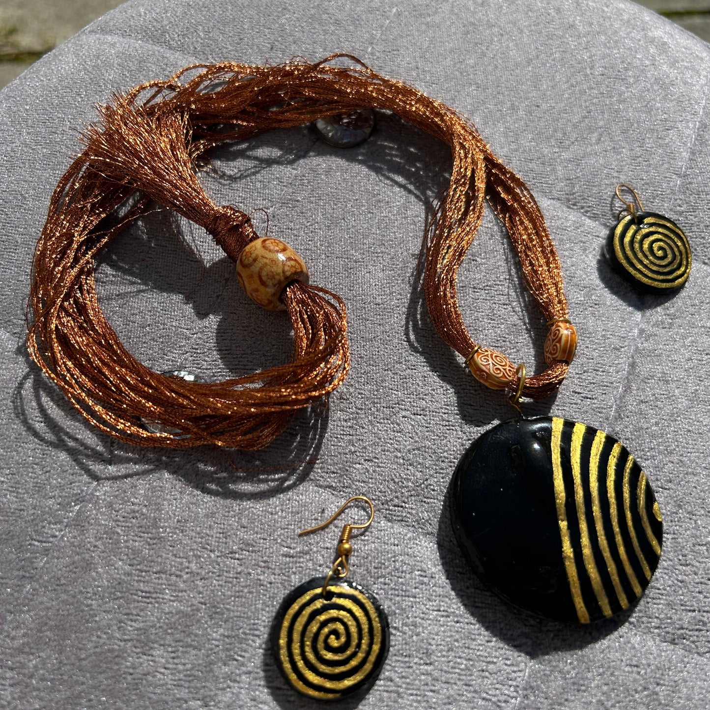 Jewelry set with a bracelet and two earrings on a textured surface