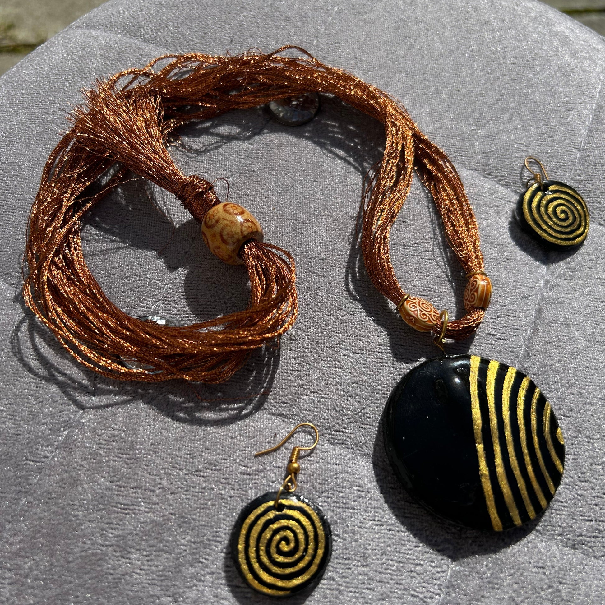 Jewelry set with a bracelet and two earrings on a textured surface