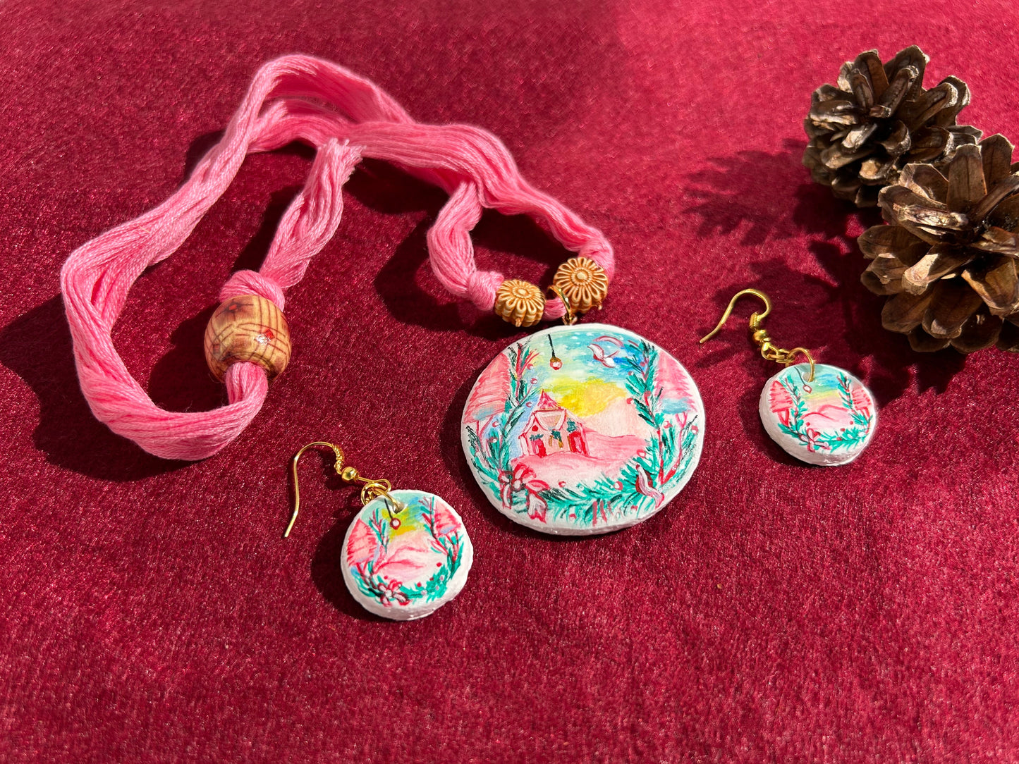 Jewelry set with pink thread and floral earrings on a red background