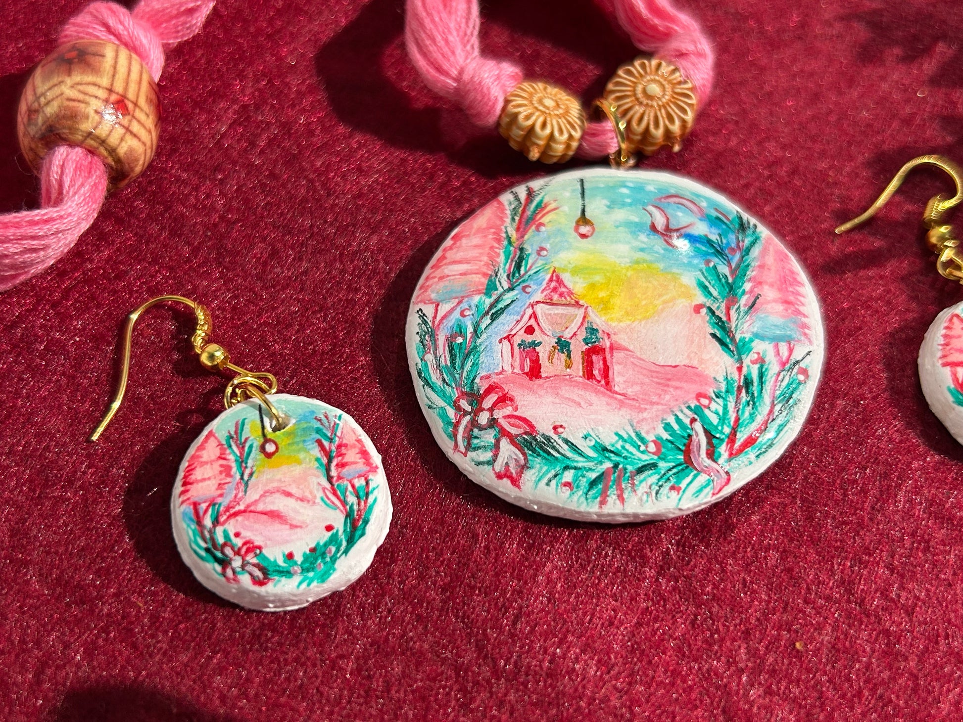 Jewelry set with round pendant and earrings on a red fabric background