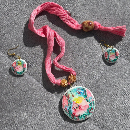 Jewelry set with floral earrings and a pink ribbon on a gray surface