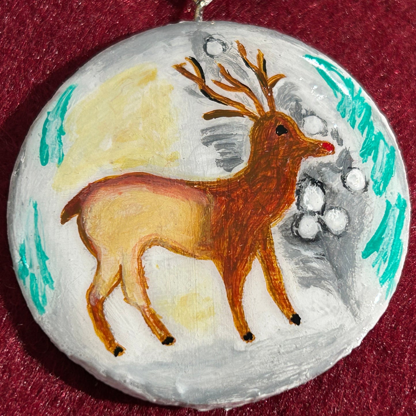 Decorative ornament with a painted reindeer on a red background