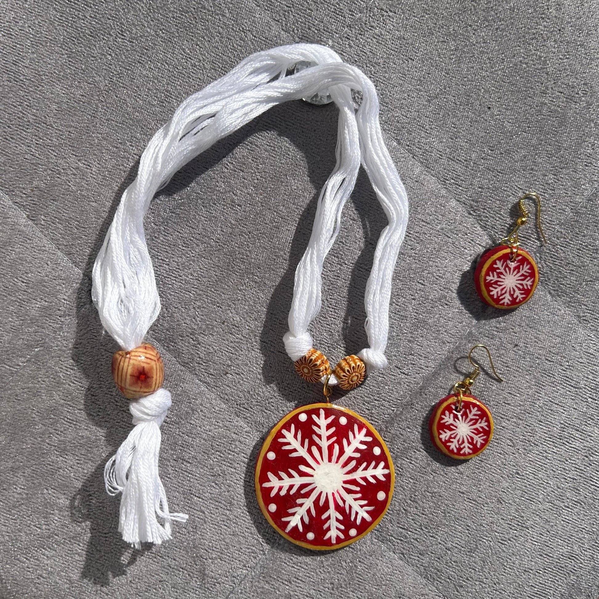 Decorative necklace set with snowflake design on a textured surface