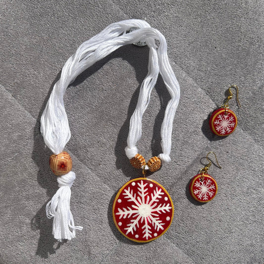 Decorative necklace set with snowflake design on a textured surface