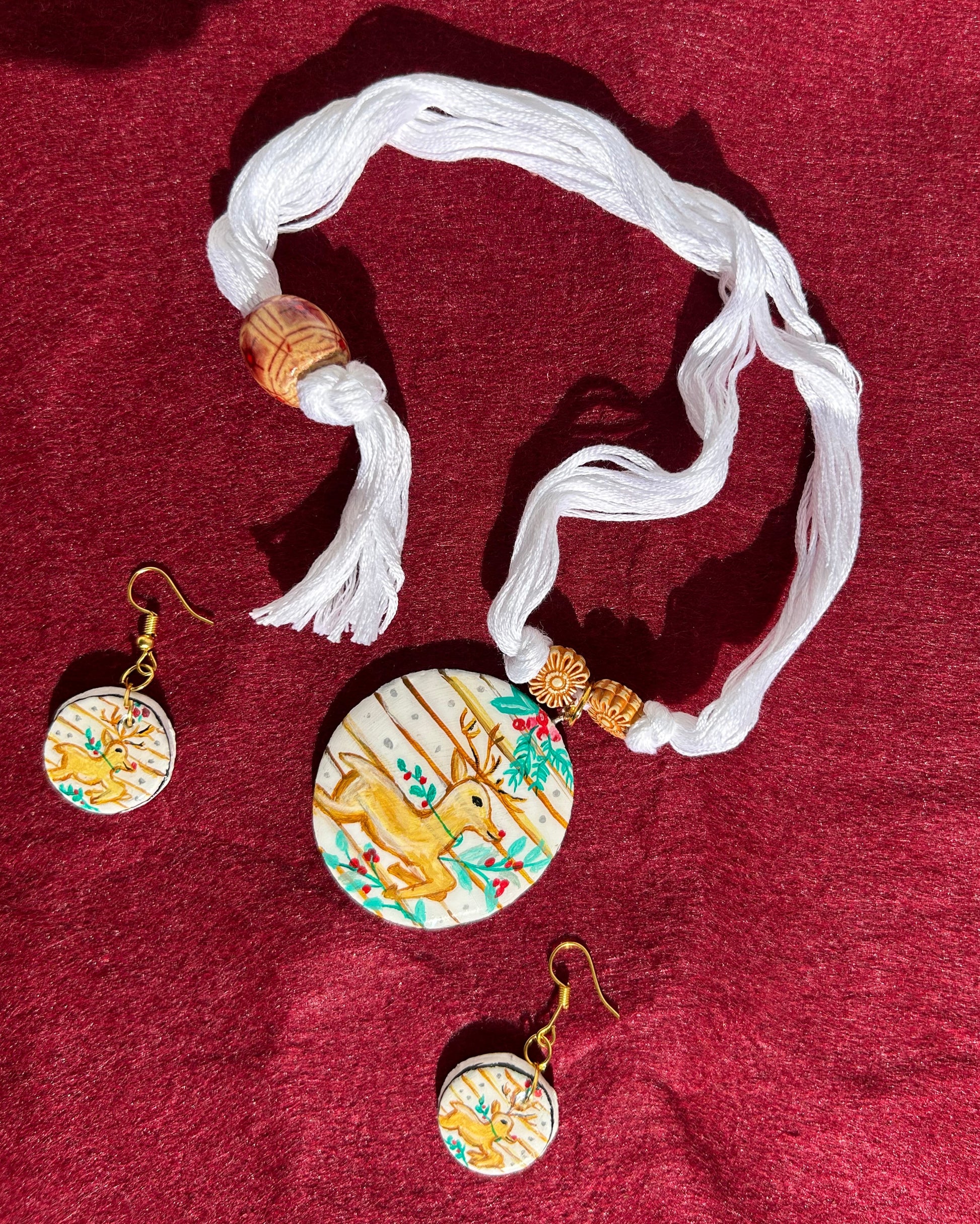 Decorative keychain with tassel and round embellishments on a red fabric background