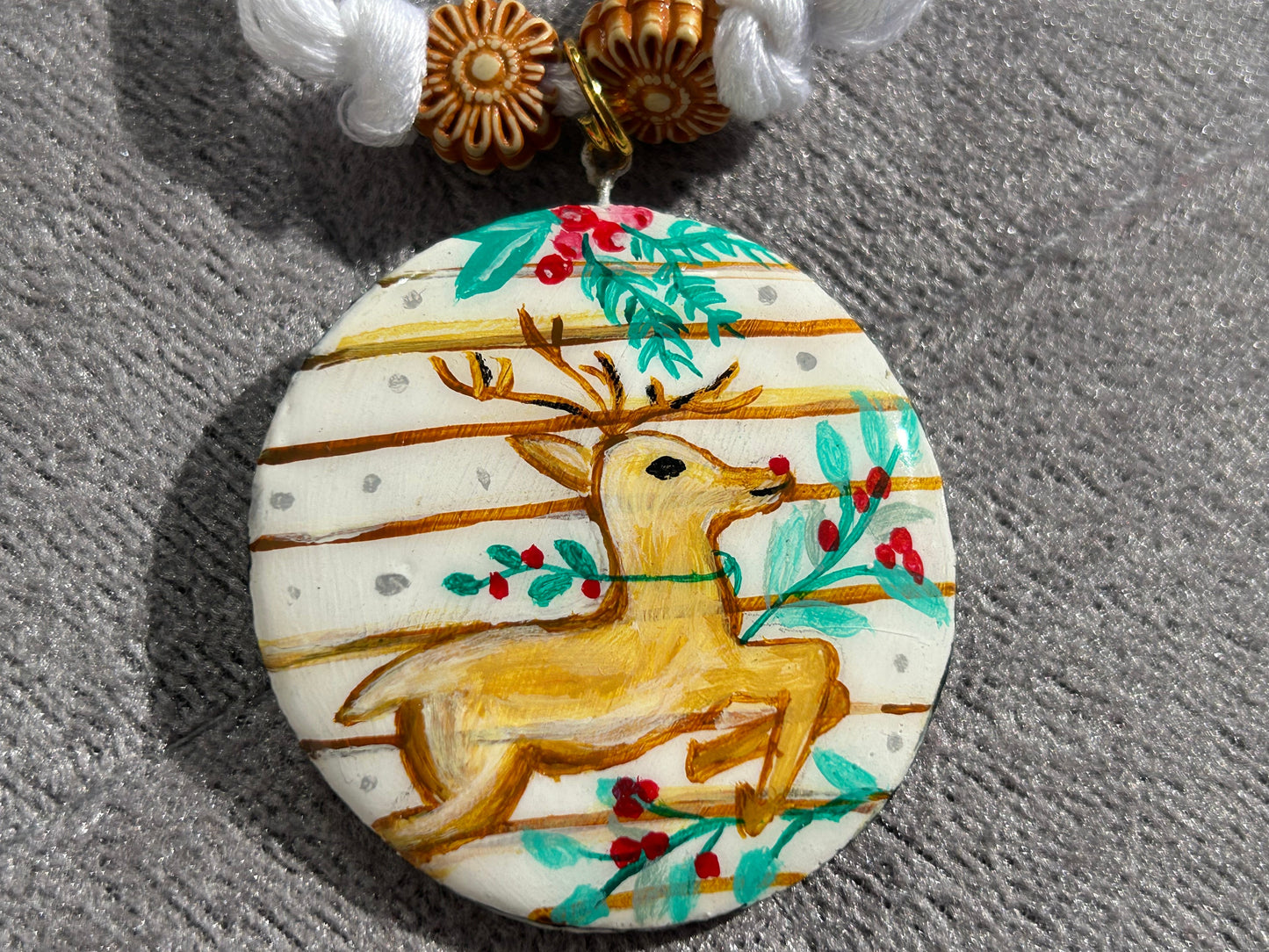 Decorative pendant with a reindeer design on a textured surface