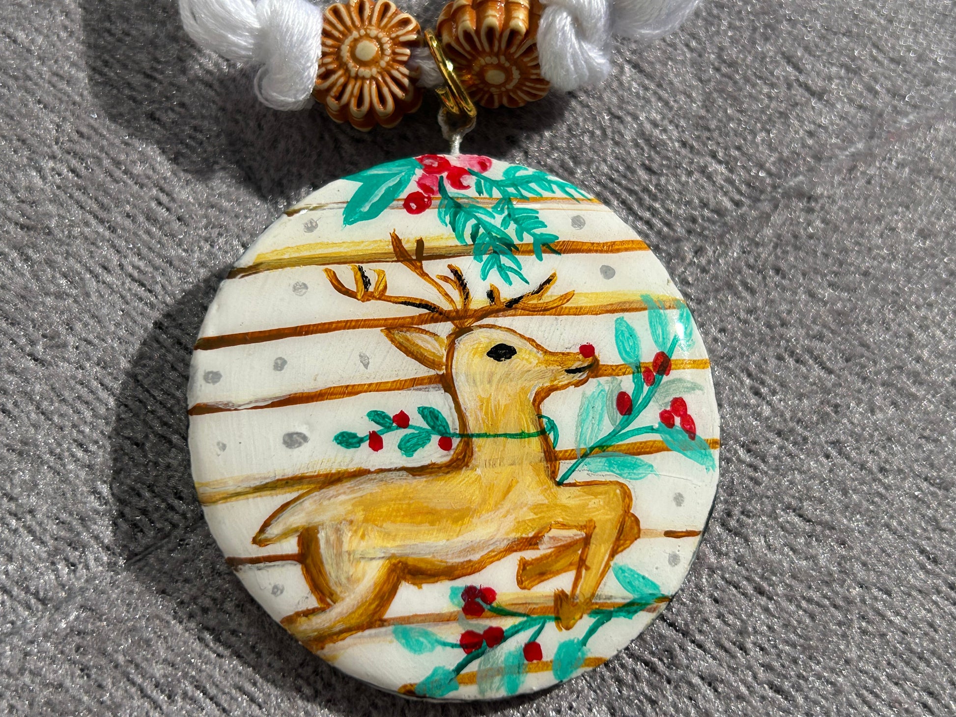 Decorative pendant with a reindeer design on a textured surface