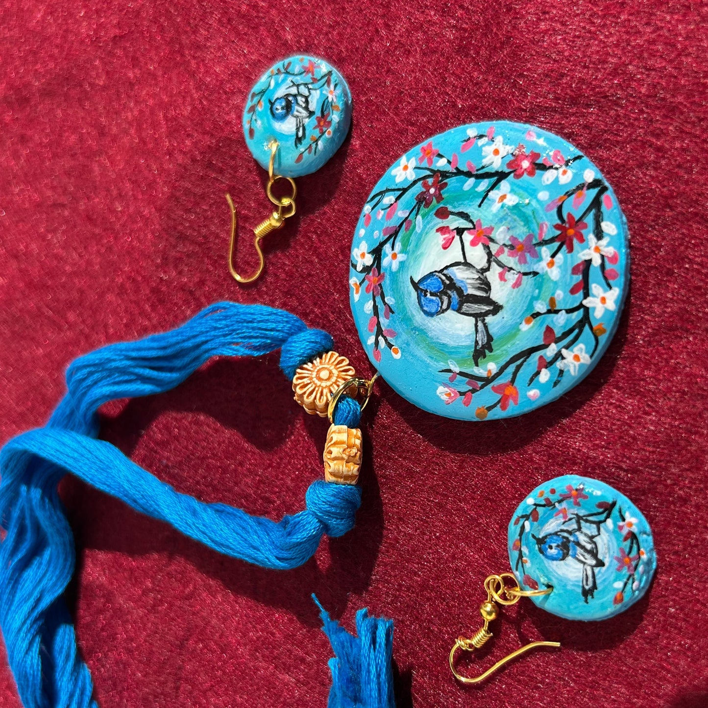 Jewelry set with blue tassels on a red fabric background