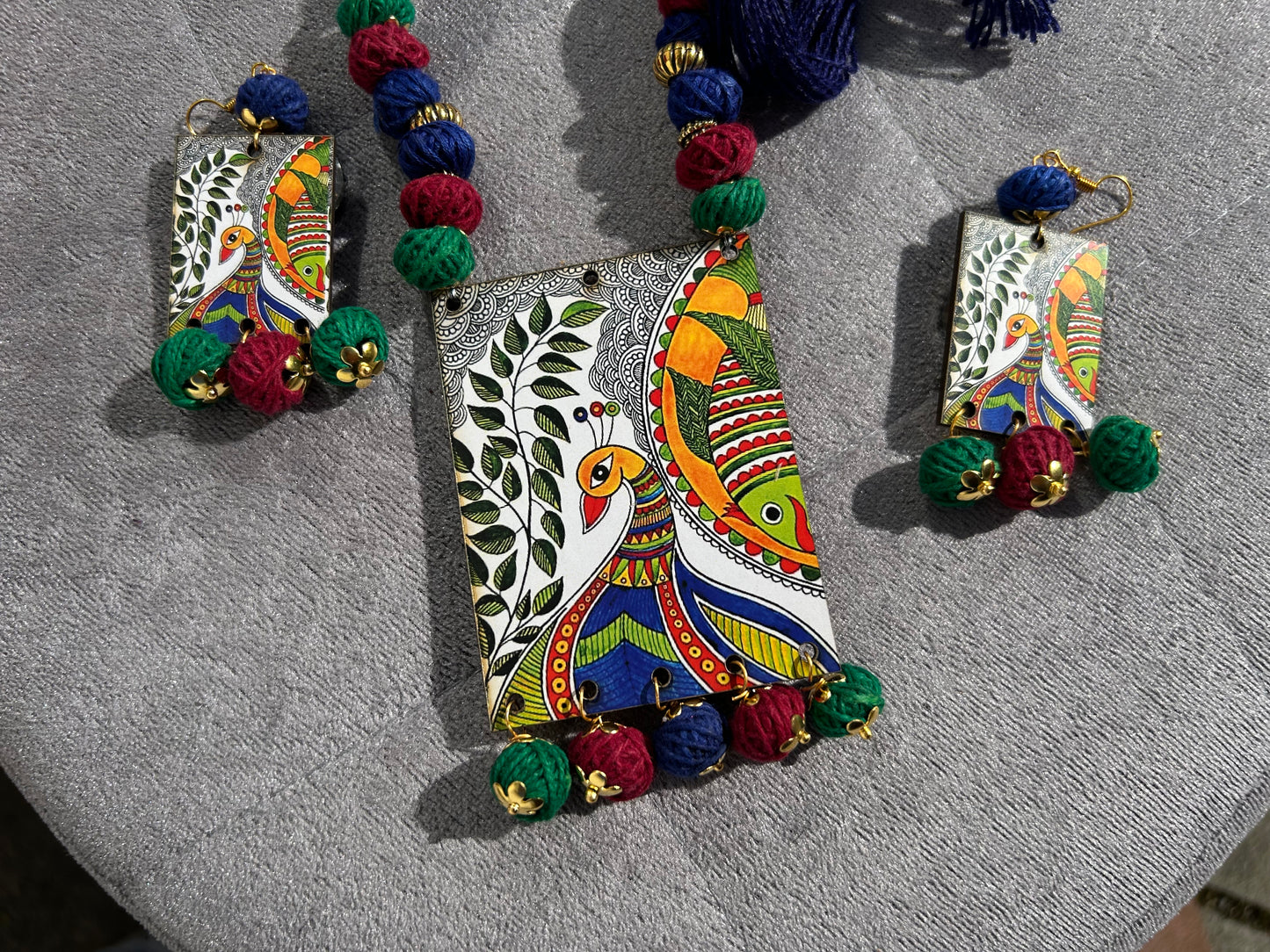 Colorful earrings with intricate designs on a gray surface
