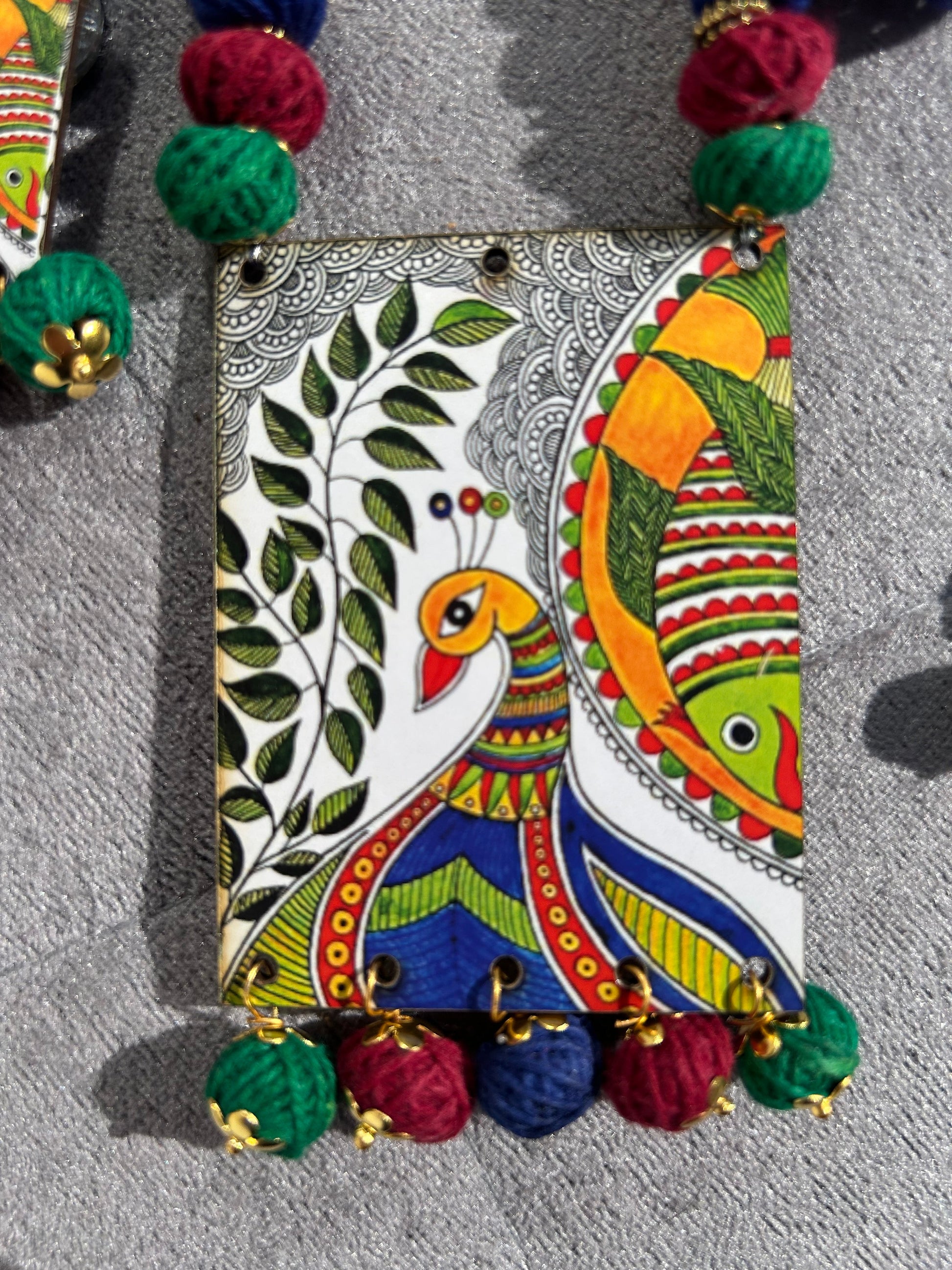 Colorful hand-painted clutch bag with decorative elements on a gray background