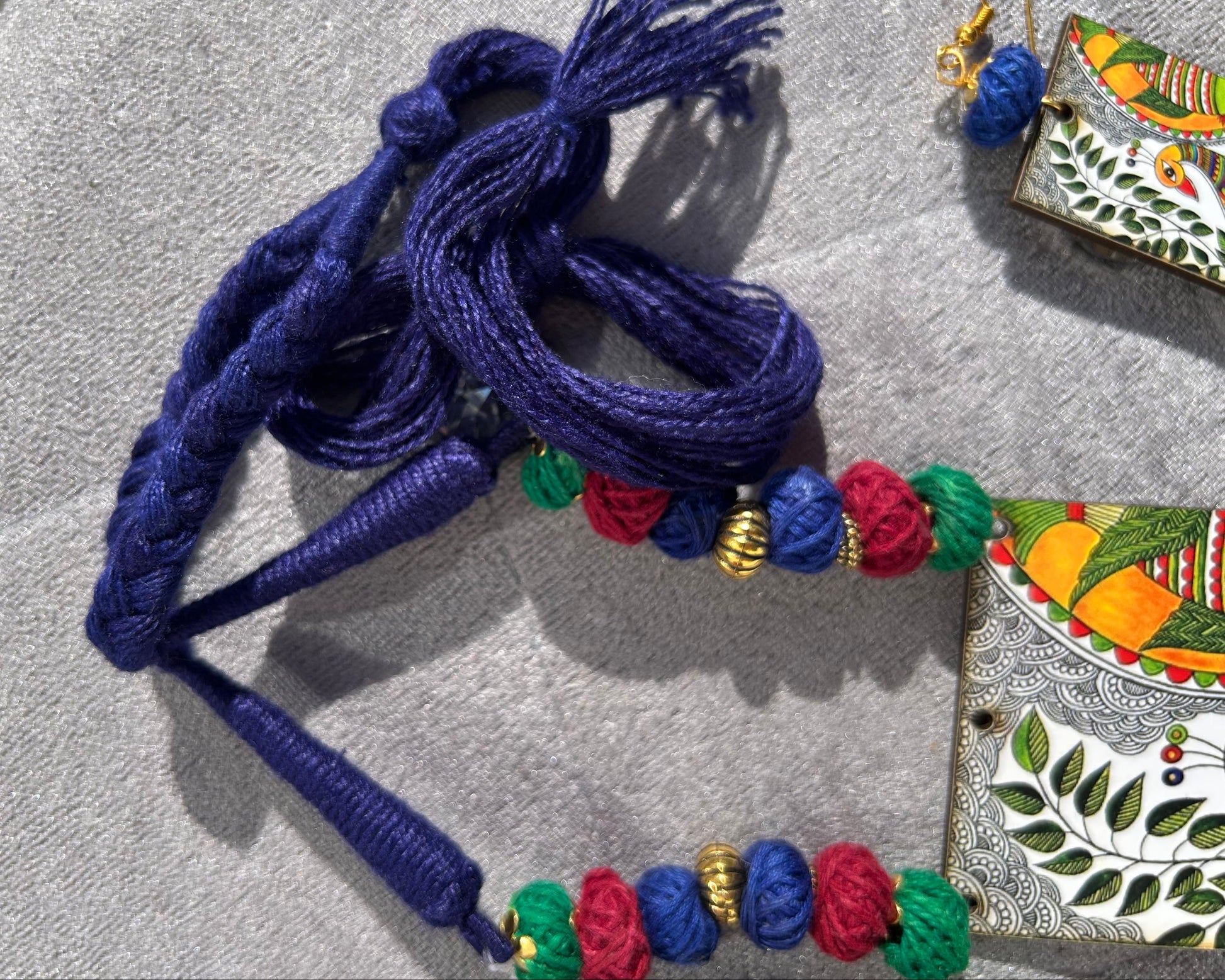 Decorative blue cord with colorful beads on a textured surface