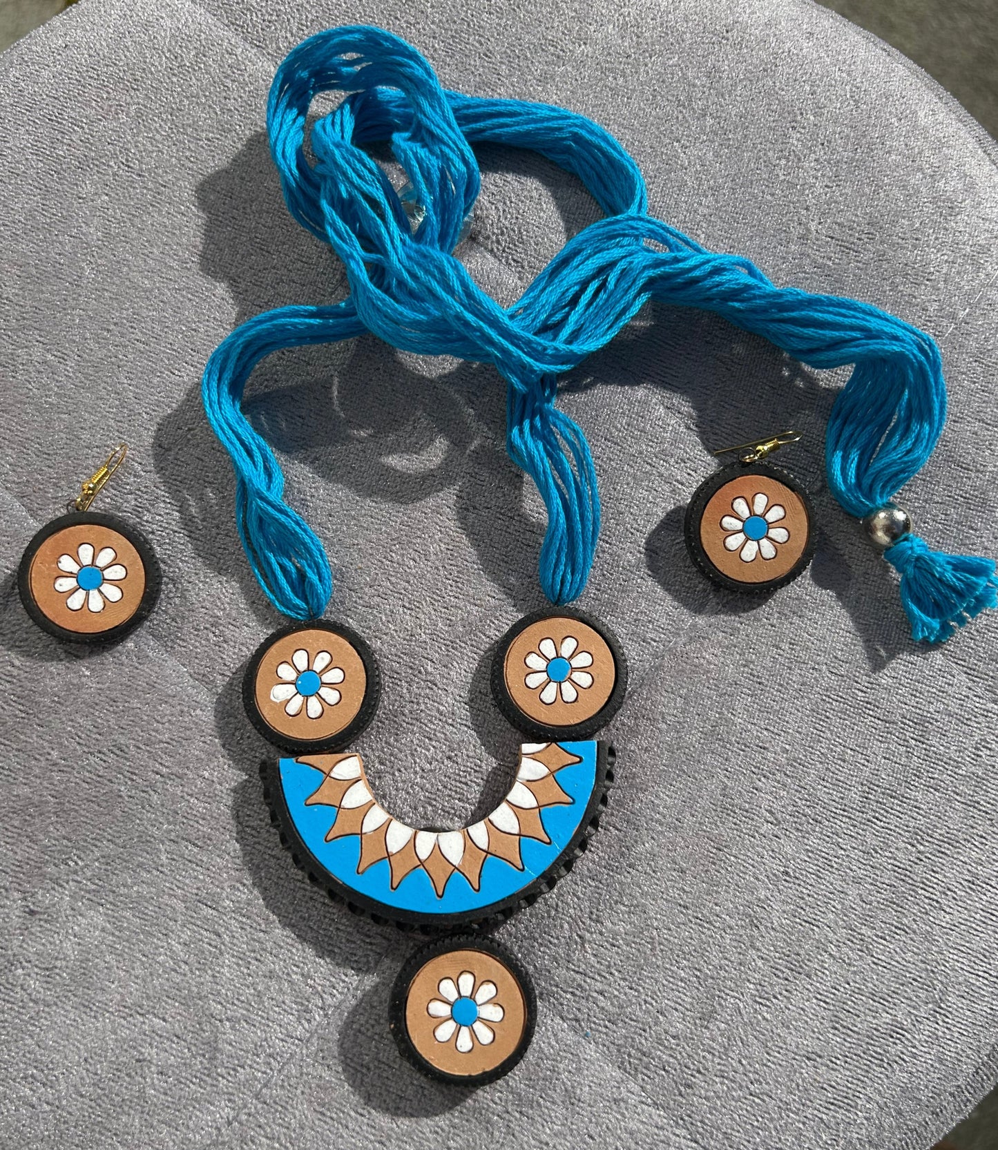 Decorative buttons with blue thread on a gray surface