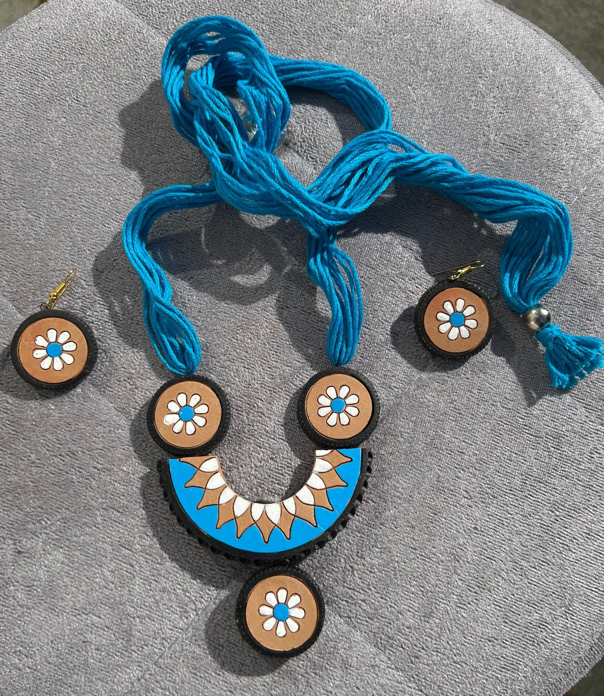 Decorative buttons with blue thread on a gray surface