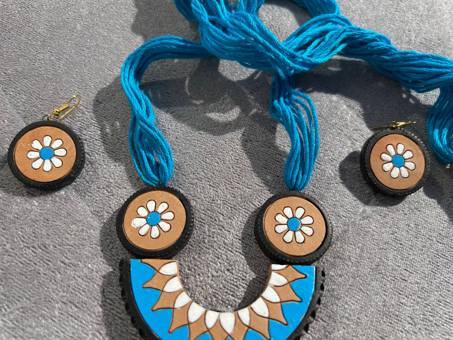 Necklace with floral pendants on a gray surface