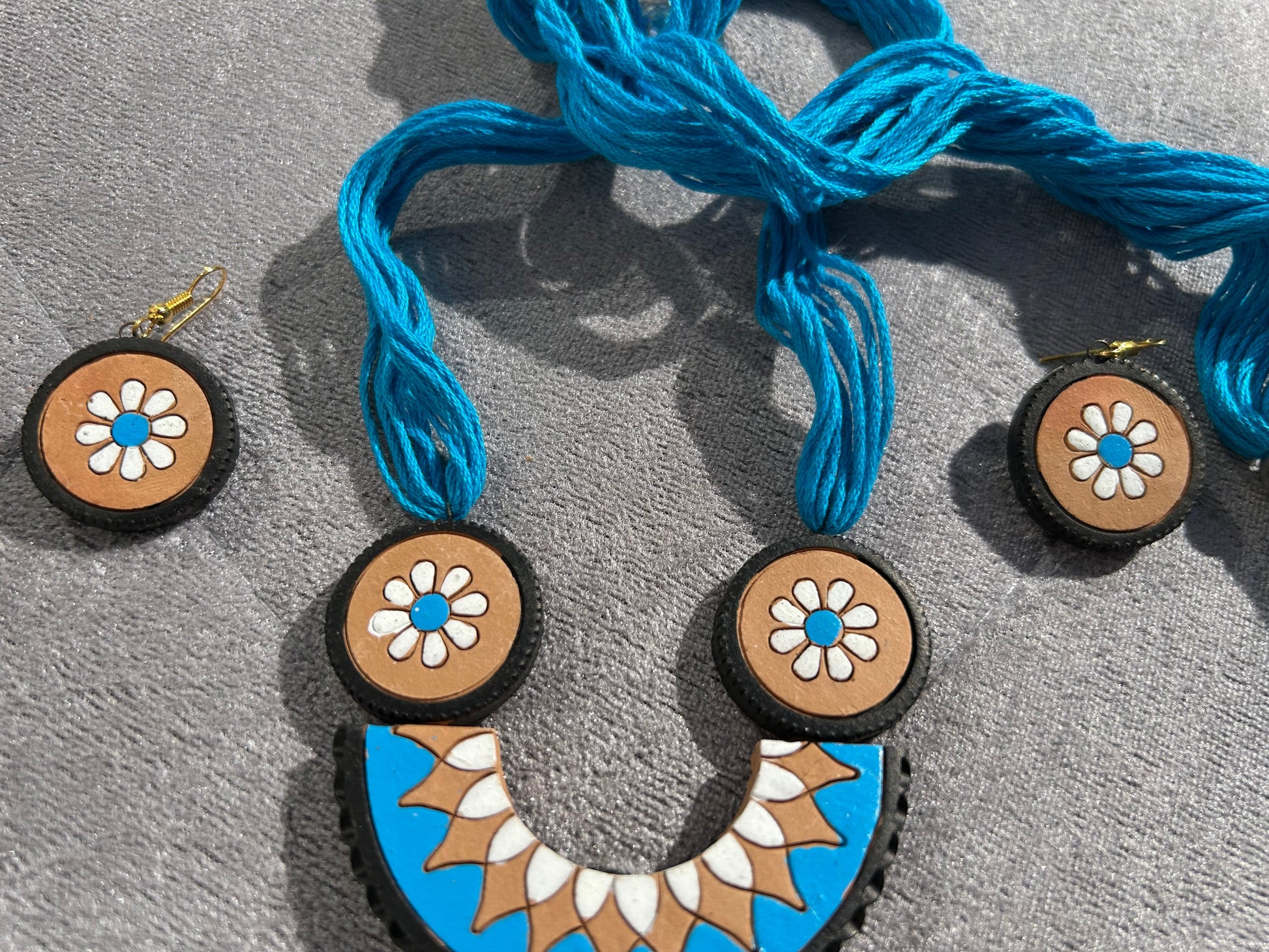 Necklace with floral pendants on a gray surface