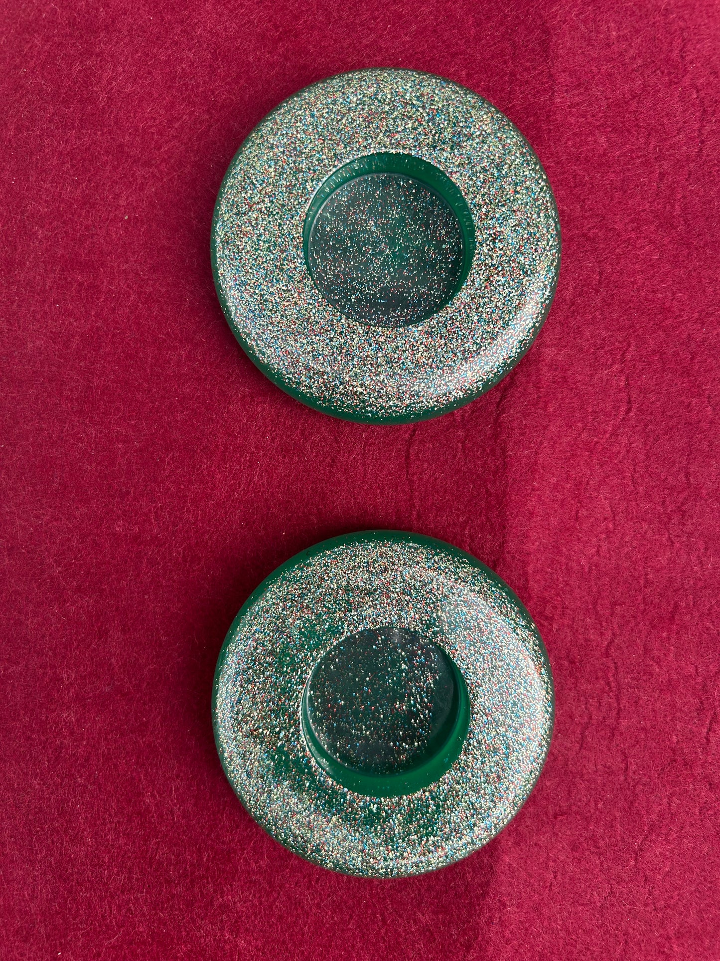 Two green circular objects on a red textured background