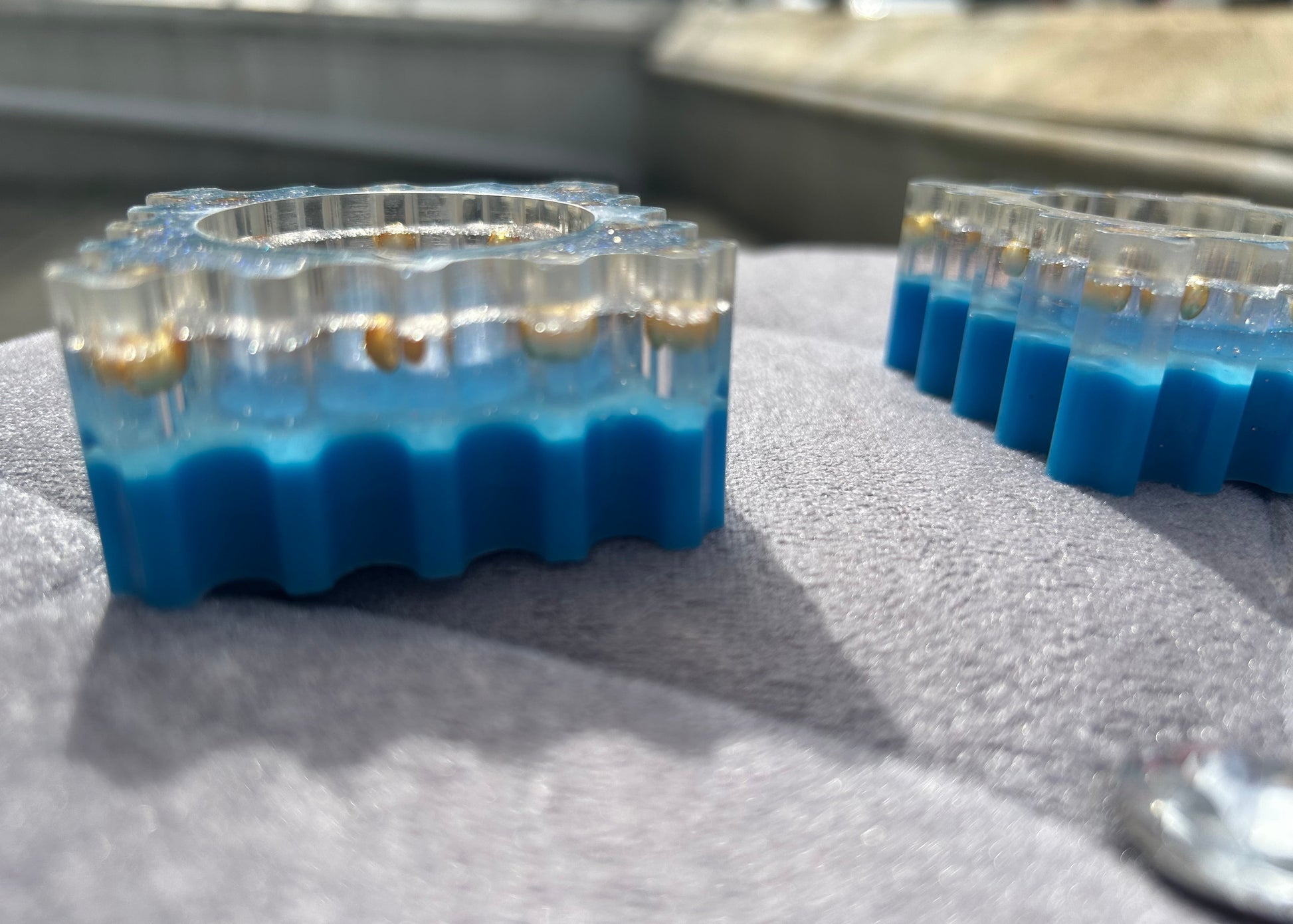 Two sets of test tubes with blue liquid on a gray surface