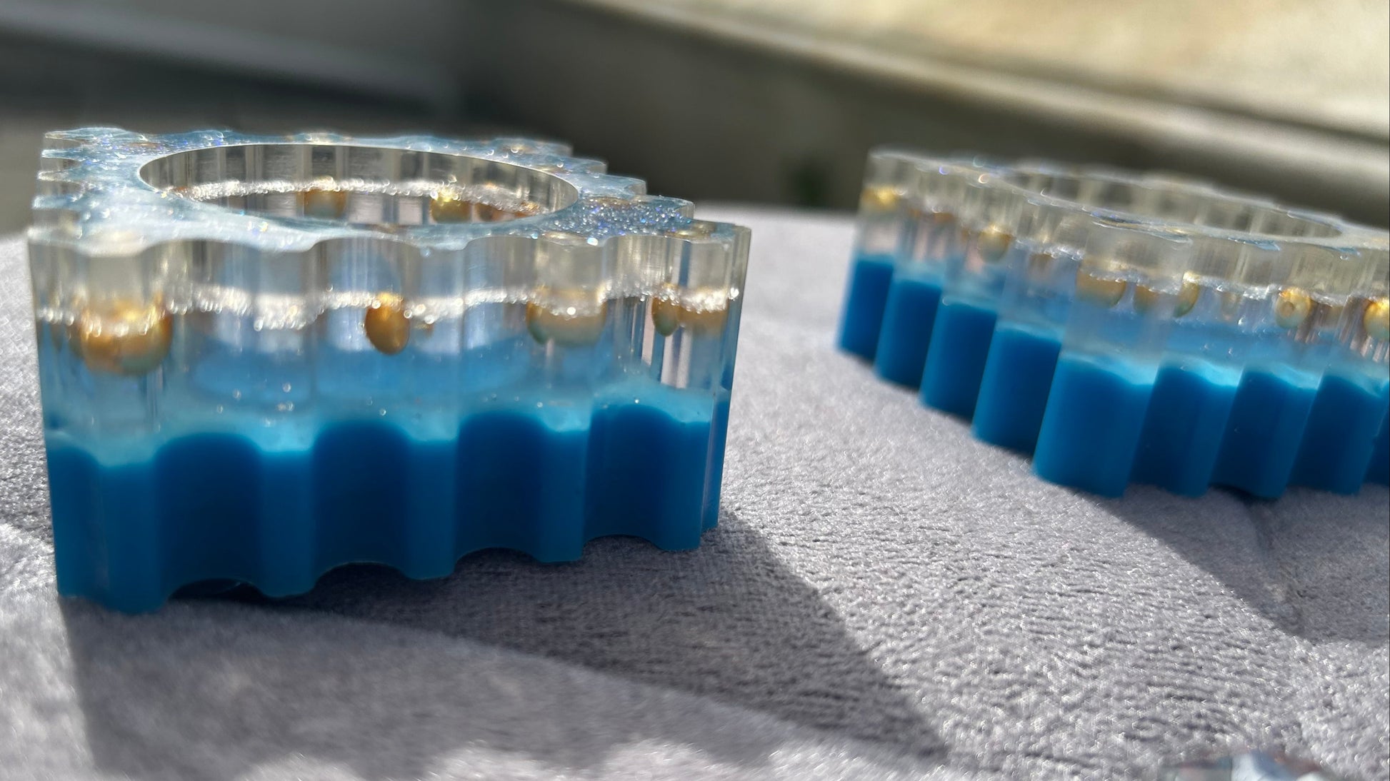 Clear plastic mold with blue silicone material on a textured surface