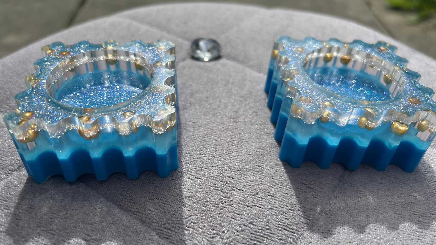 Two blue and gold decorative items on a textured surface with a blurred background