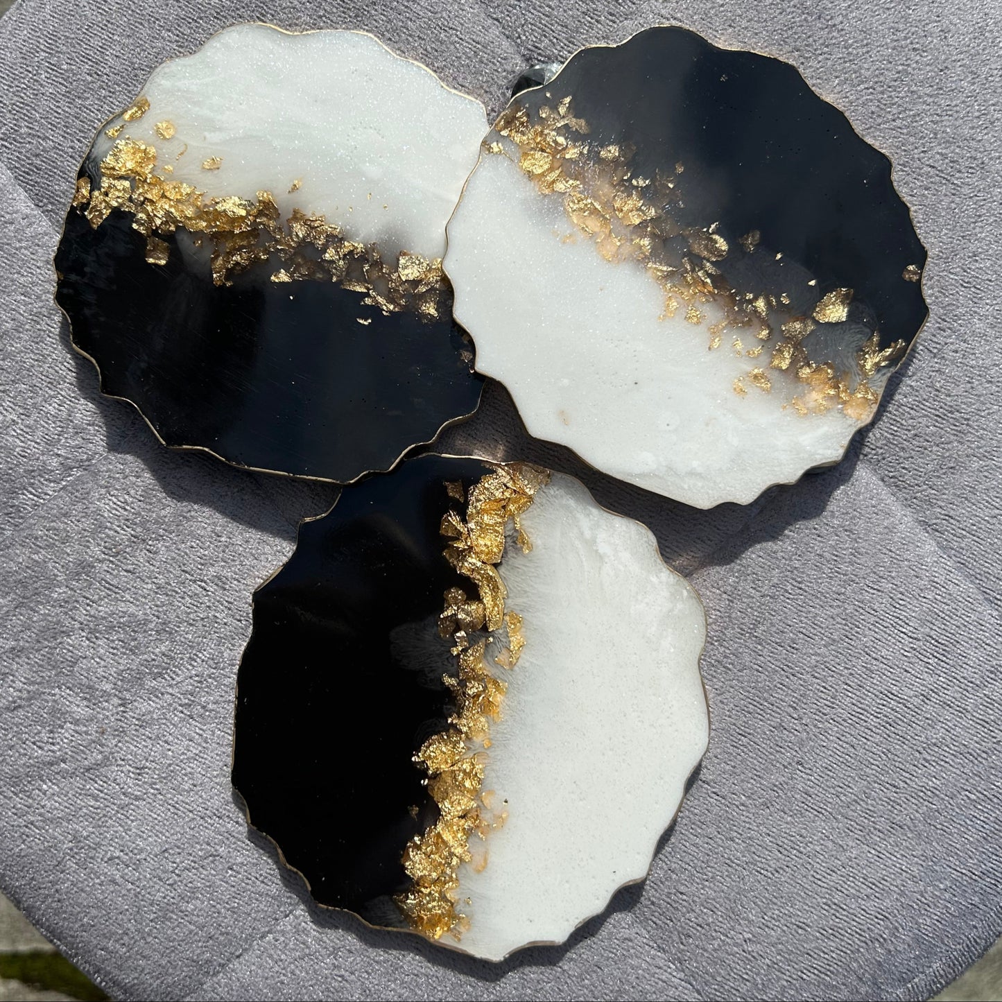 Black and white stone with gold inclusions on a gray surface