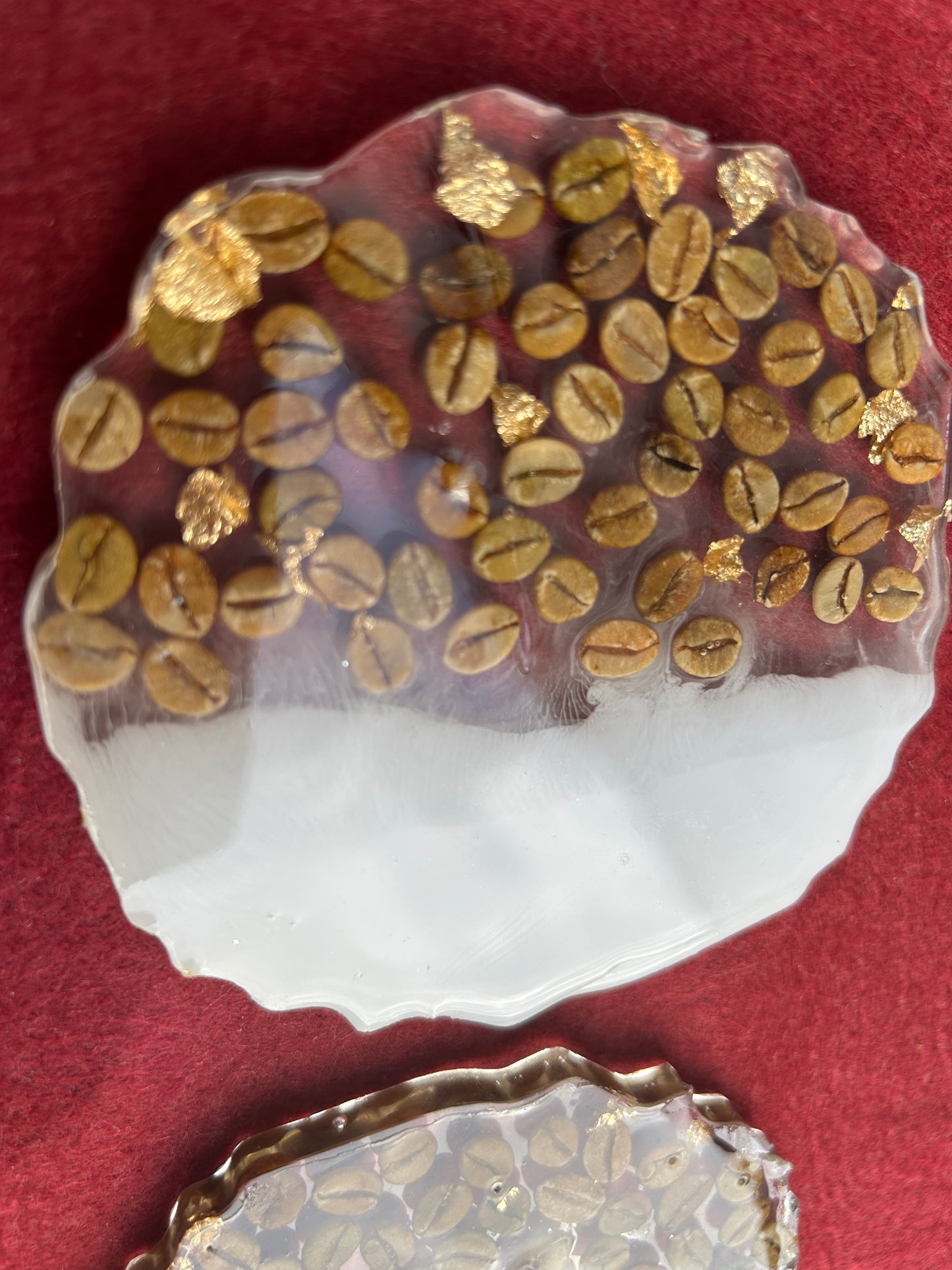 Decorative plate with gold-coated coffee beans on a red background