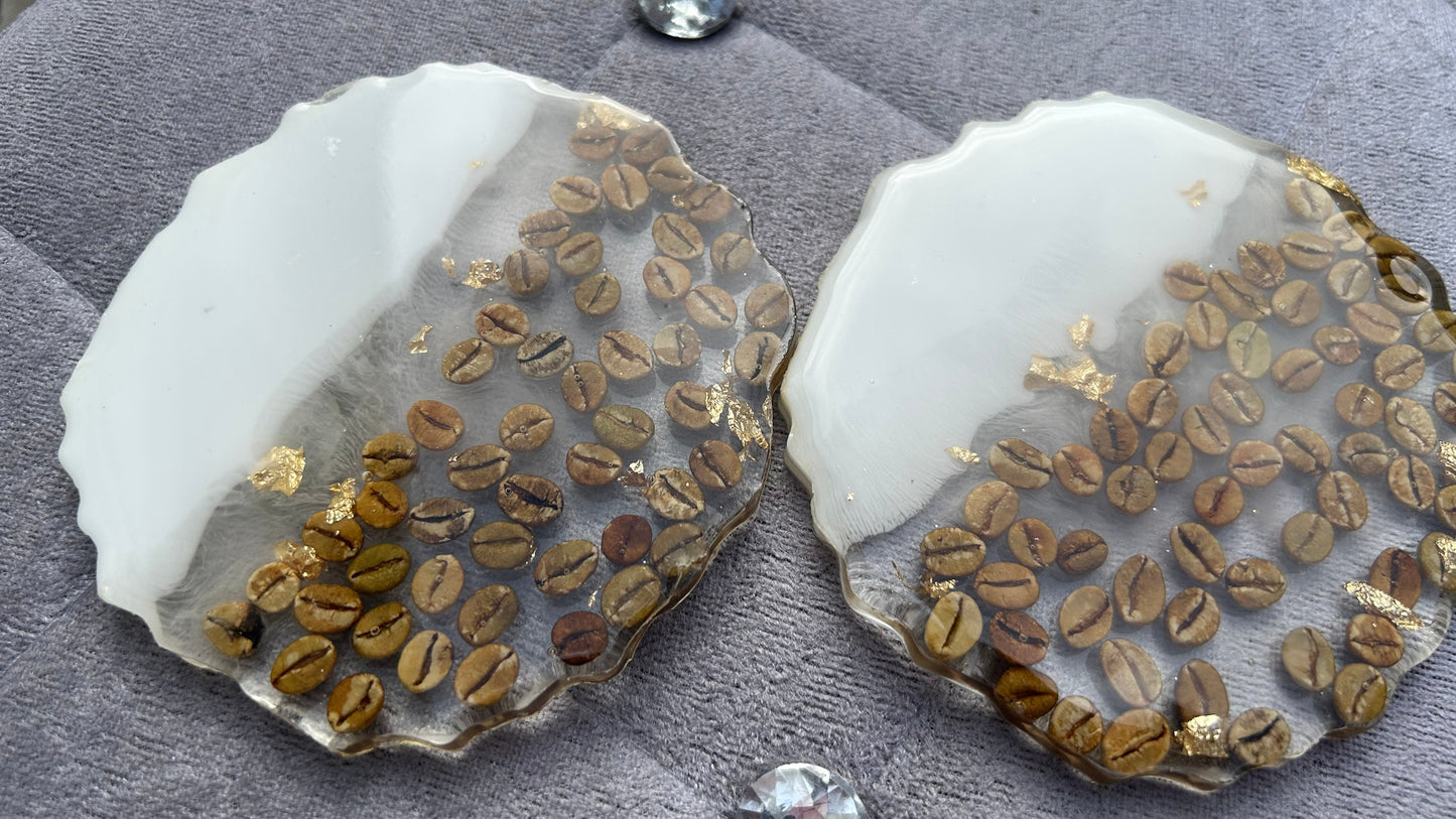 Two round stone coasters with embedded coffee beans on a gray surface.