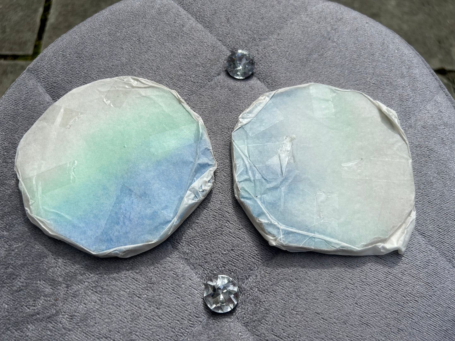 Two rough opal stones on a dark surface with two smaller polished opals beside them.
