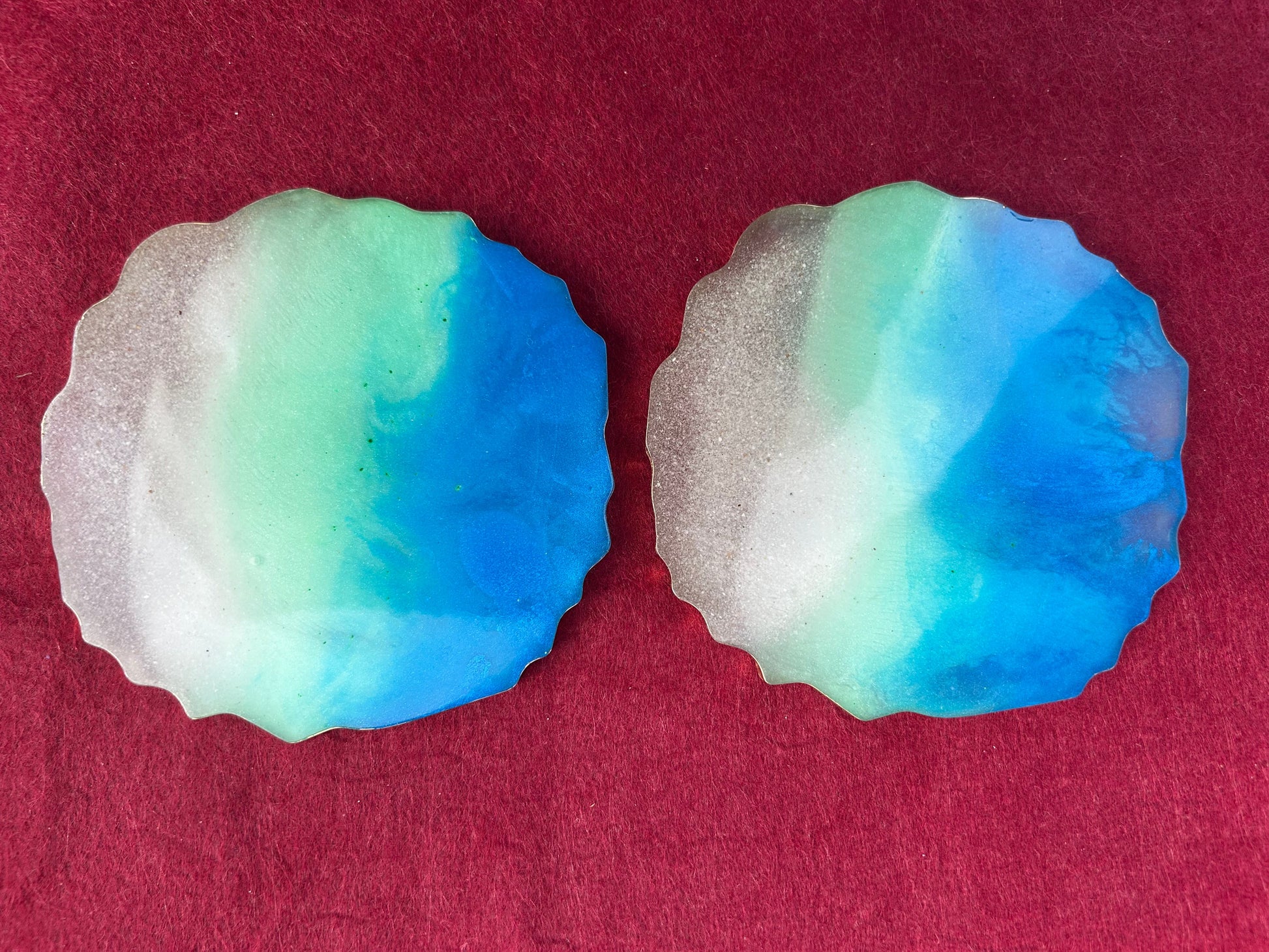 Two blue and green marbled soap bars on a red background